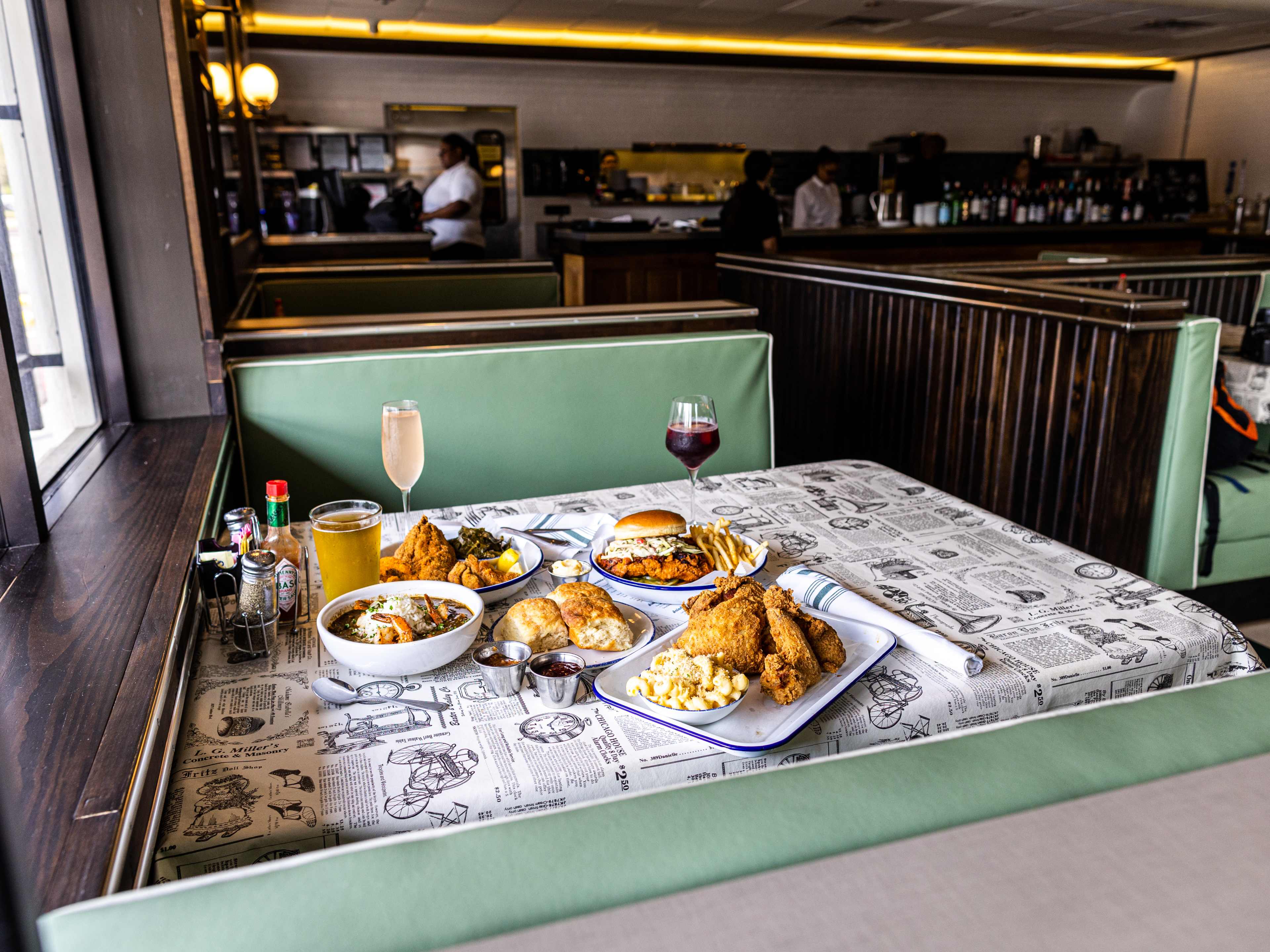 A spread of dishes at a green booth inside Gatlin's Fins & Feathers.