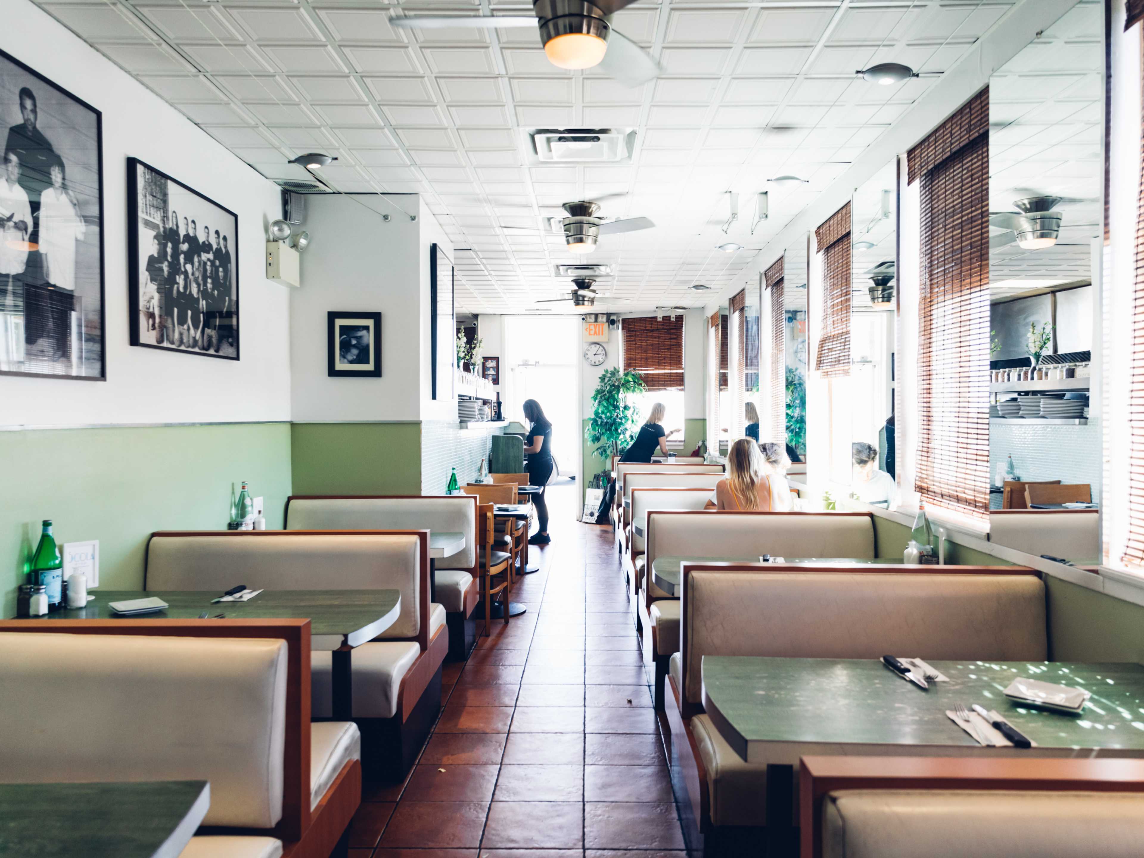 The interior of a diner with blue and white walls, booths, and black and white photos on the walls