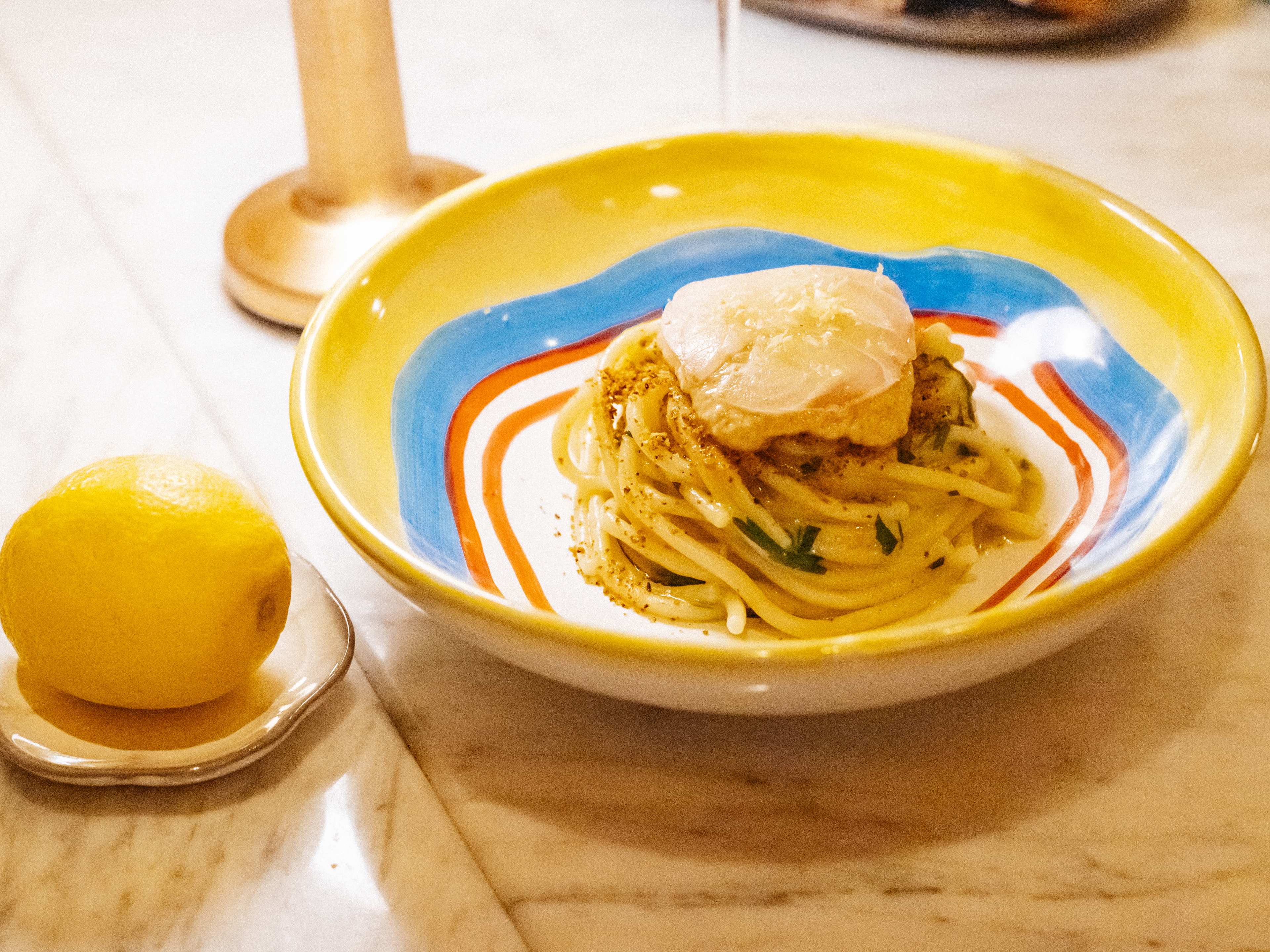 Spaghetti dish with whole lemon on the side at Giano