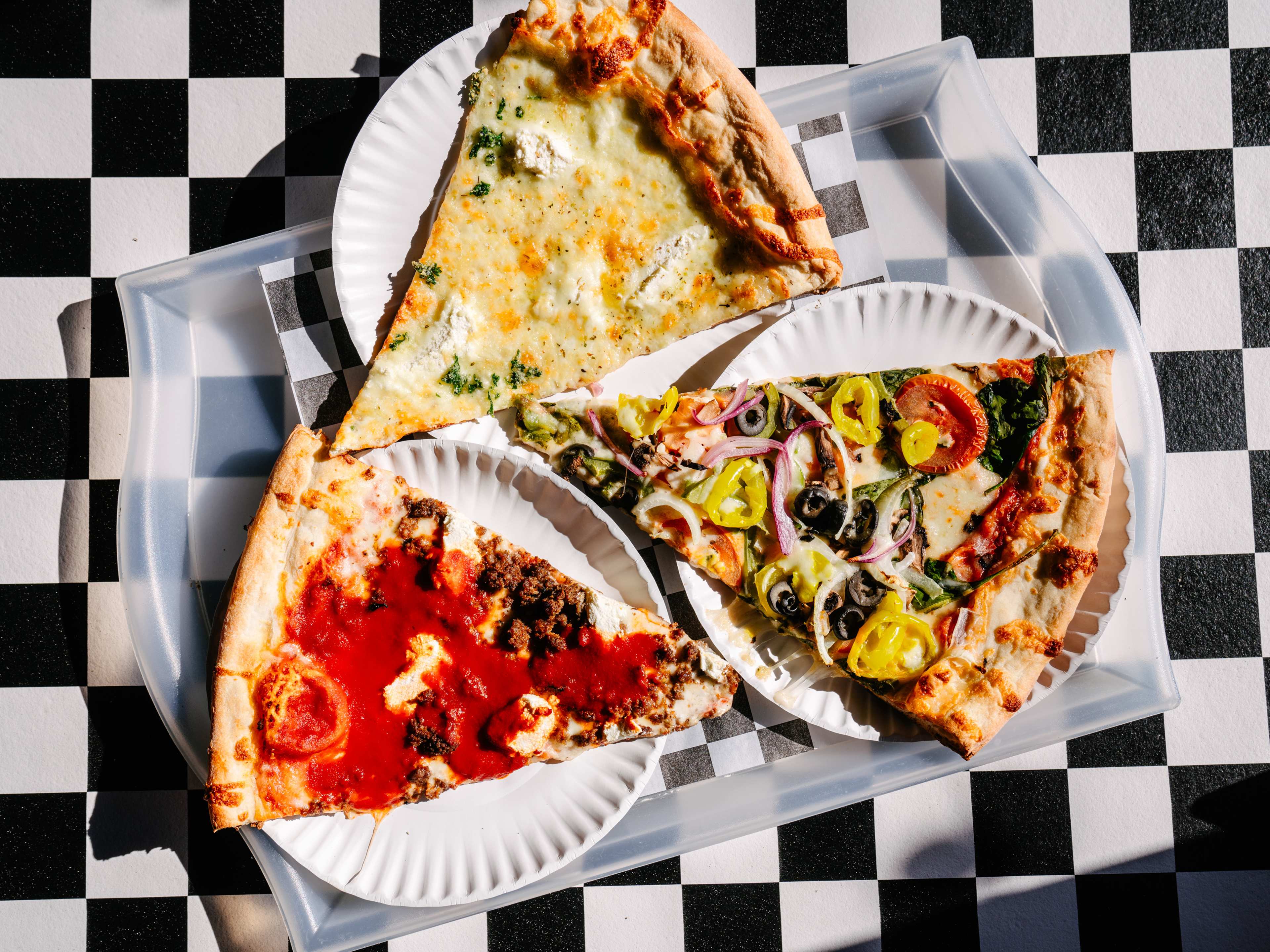 Three slices of pizza on paper plates.