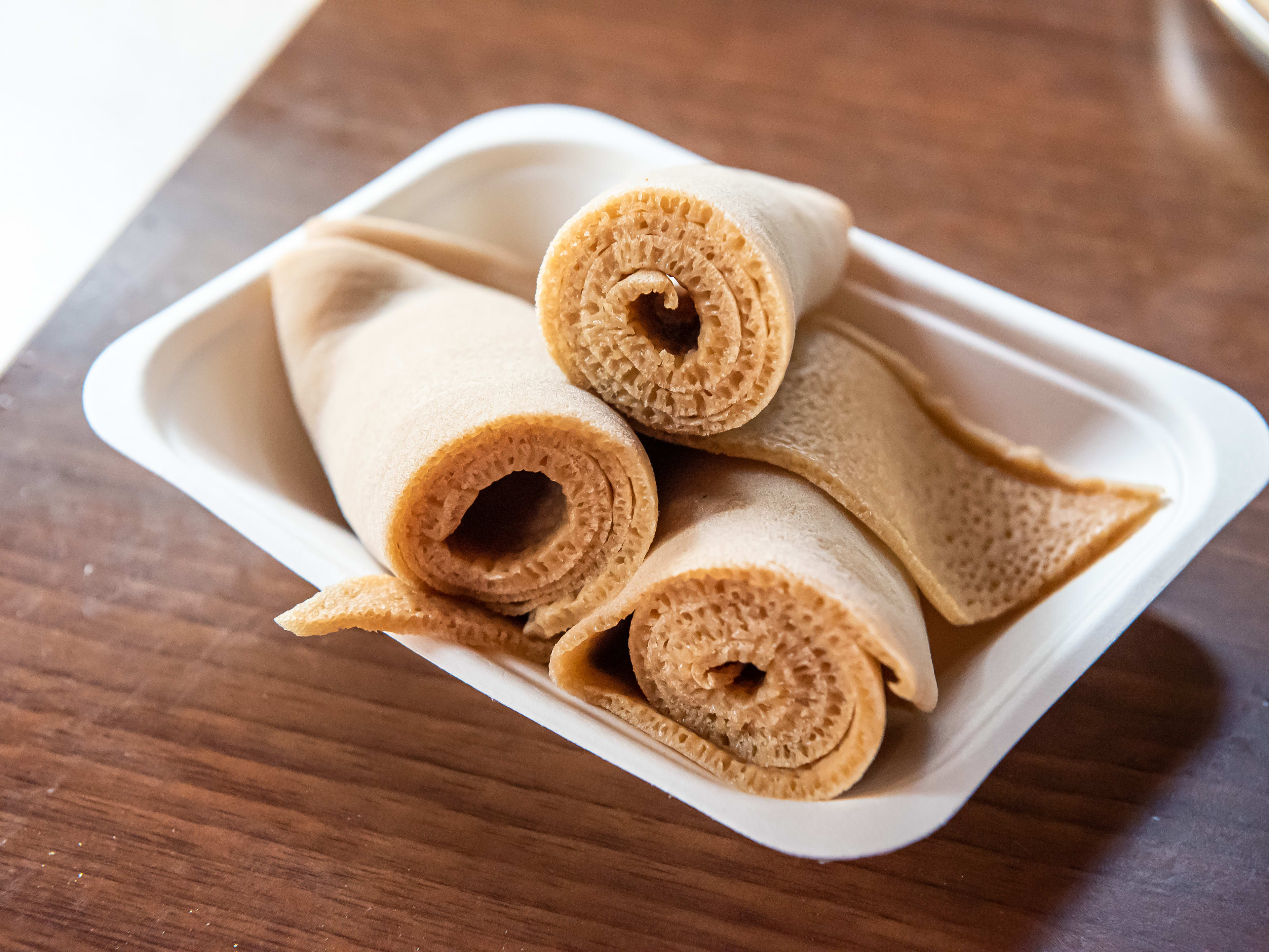 rolls of injera bread piled on a plate.