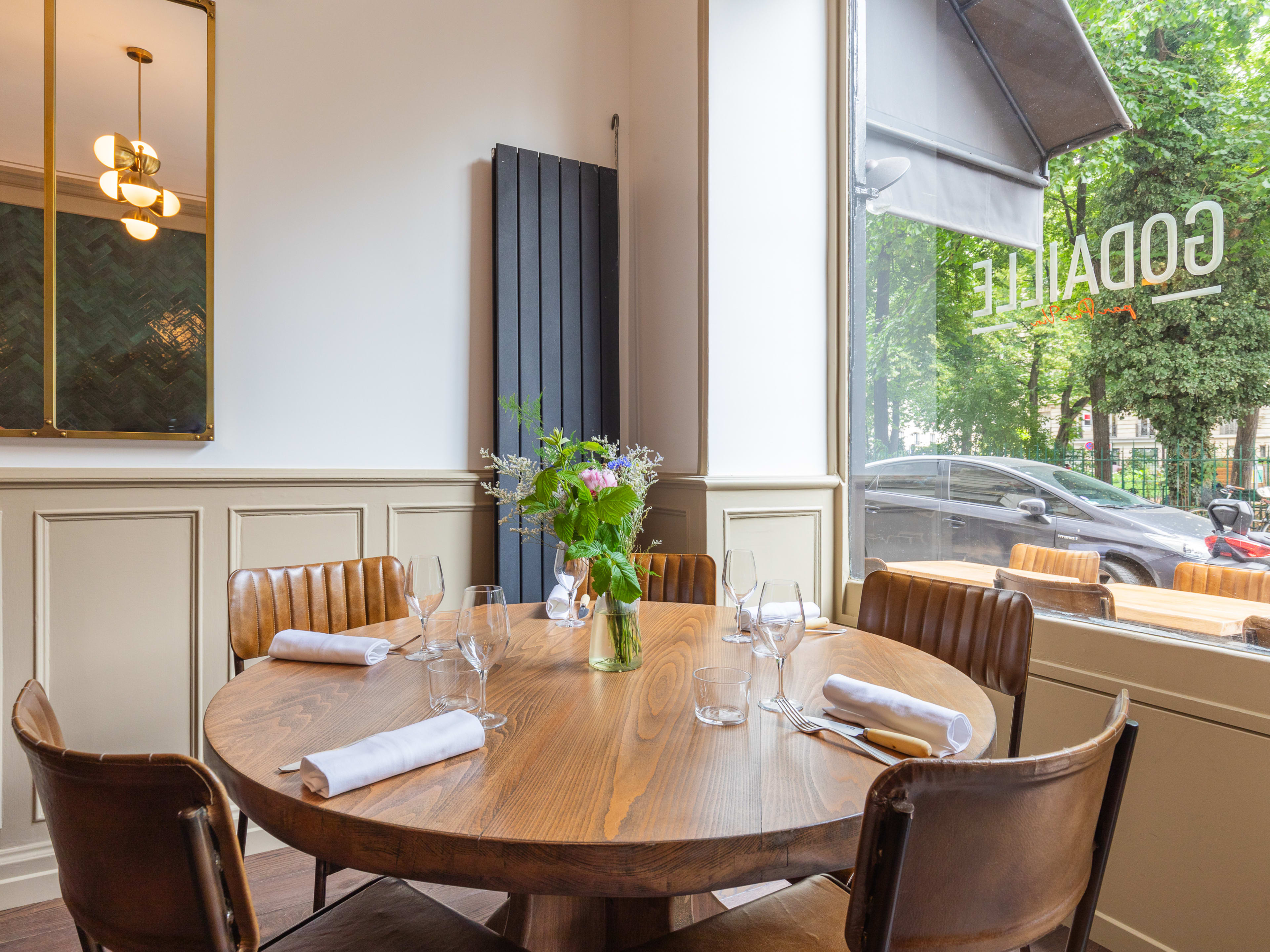 A corner table right in front of a big window inside Godaille, a restaurant in Paris