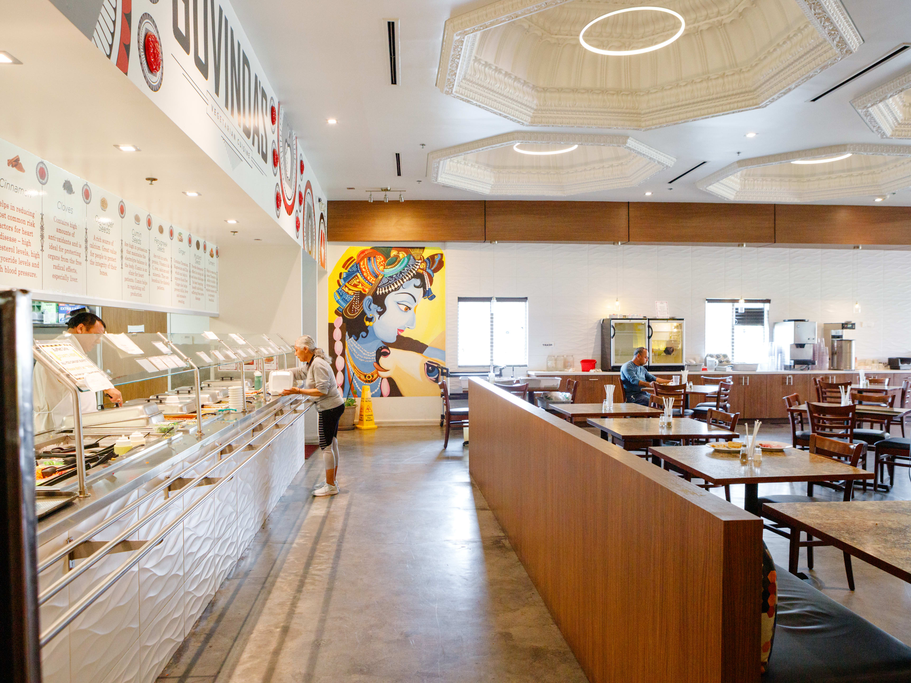 The interior at Govinda’s Vegetarian. A person gets food from the the all-you-can-eat buffet.