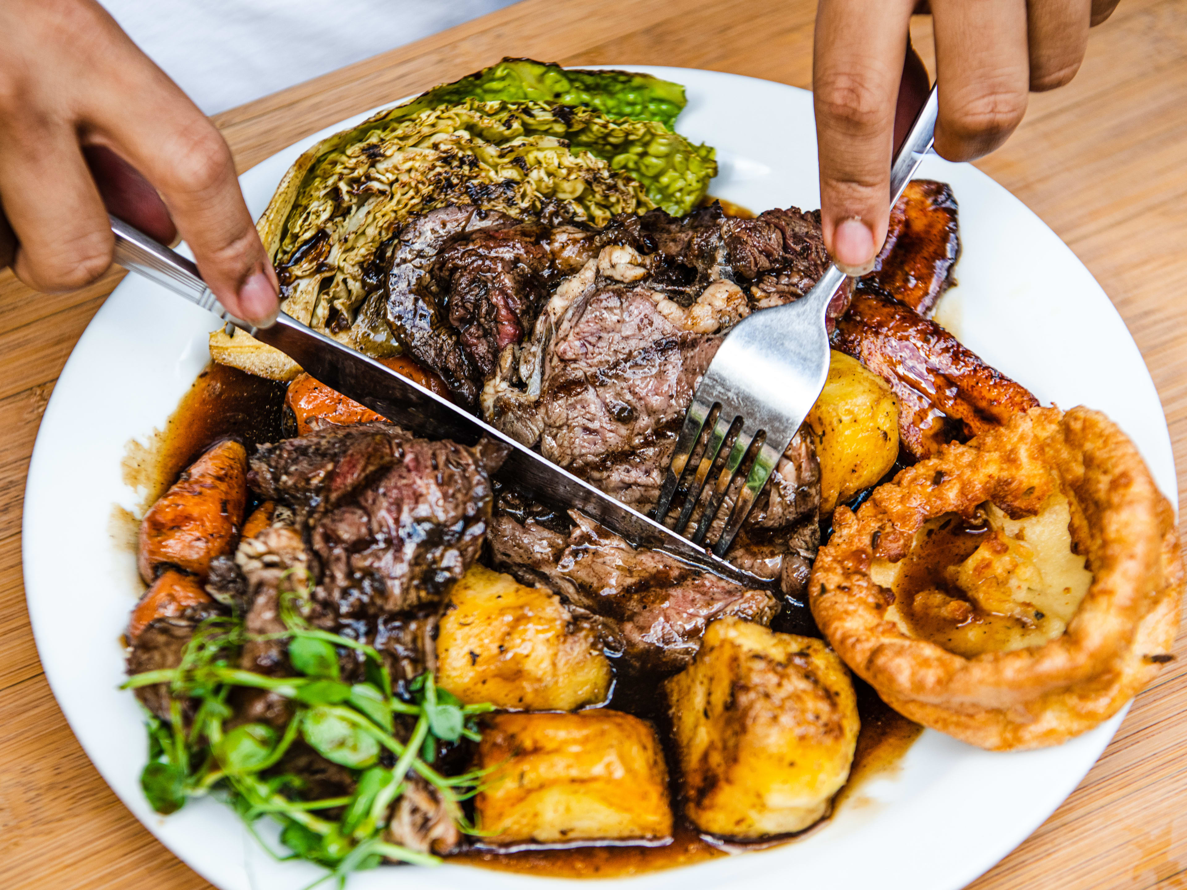 Person cutting into the jerk beef Sunday roast