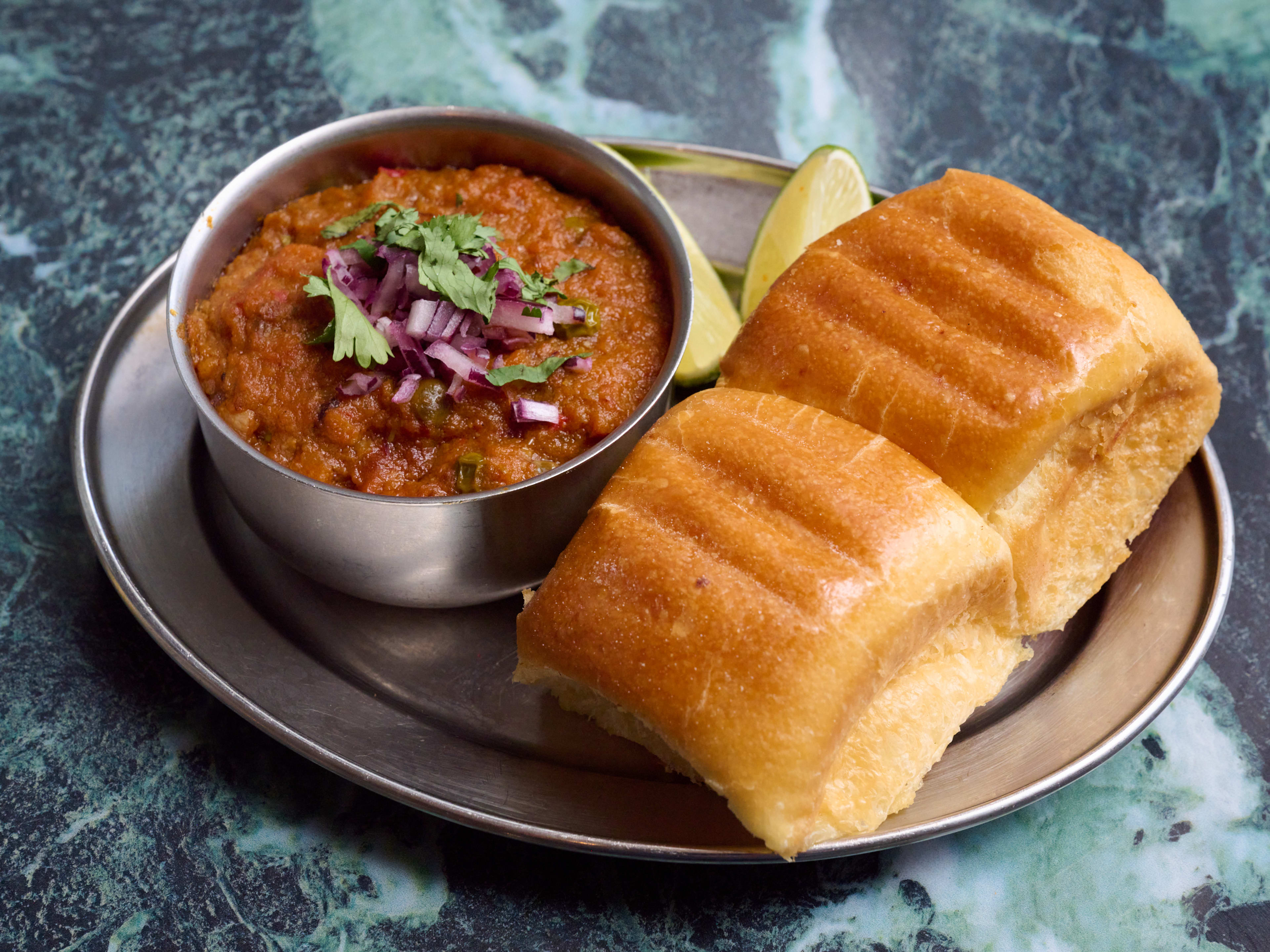 Chana masala with fresh lime and a side of two rolls at Delhi Bazaar