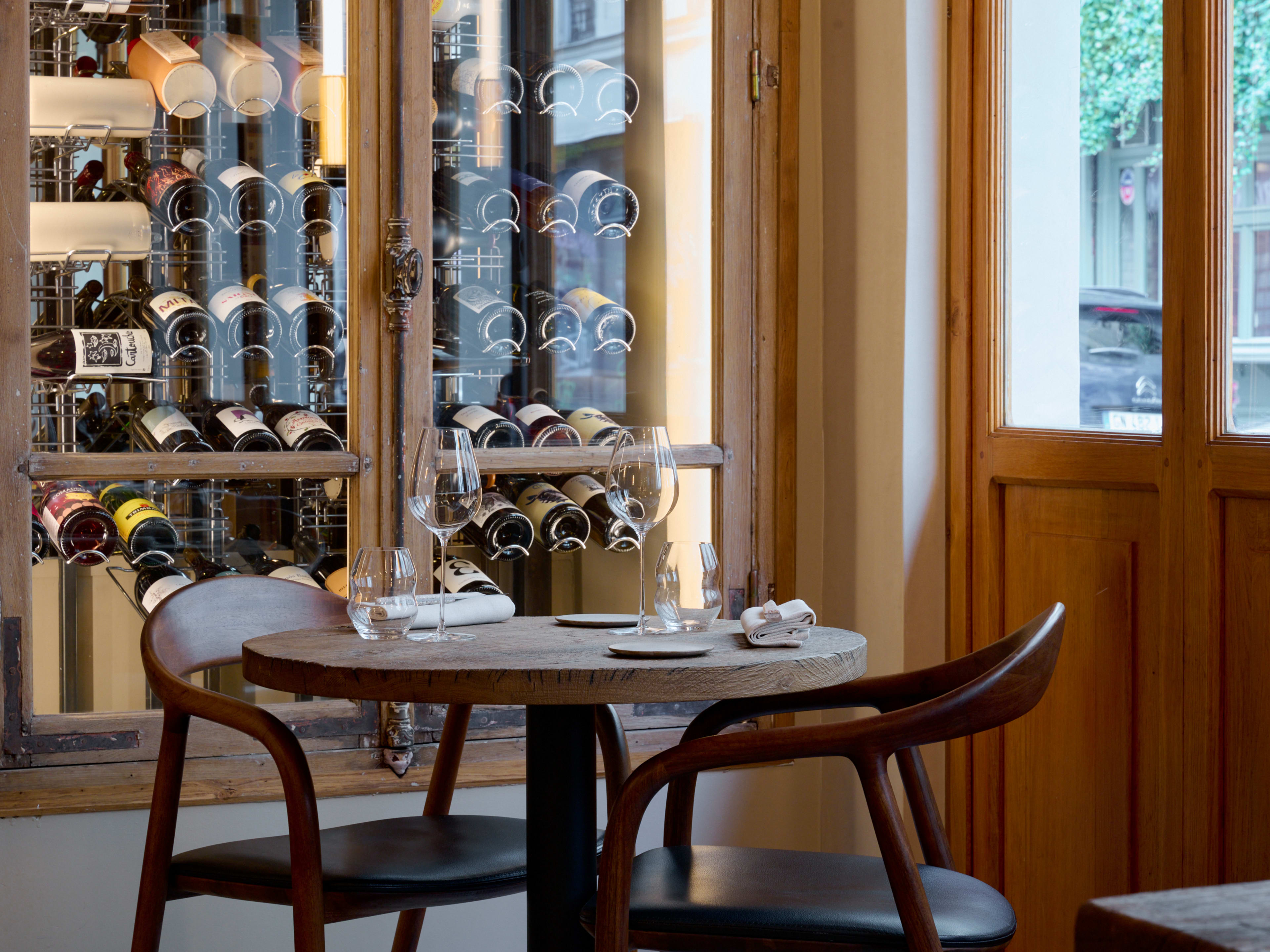 Wooden table set with glassware near window at Géosmine