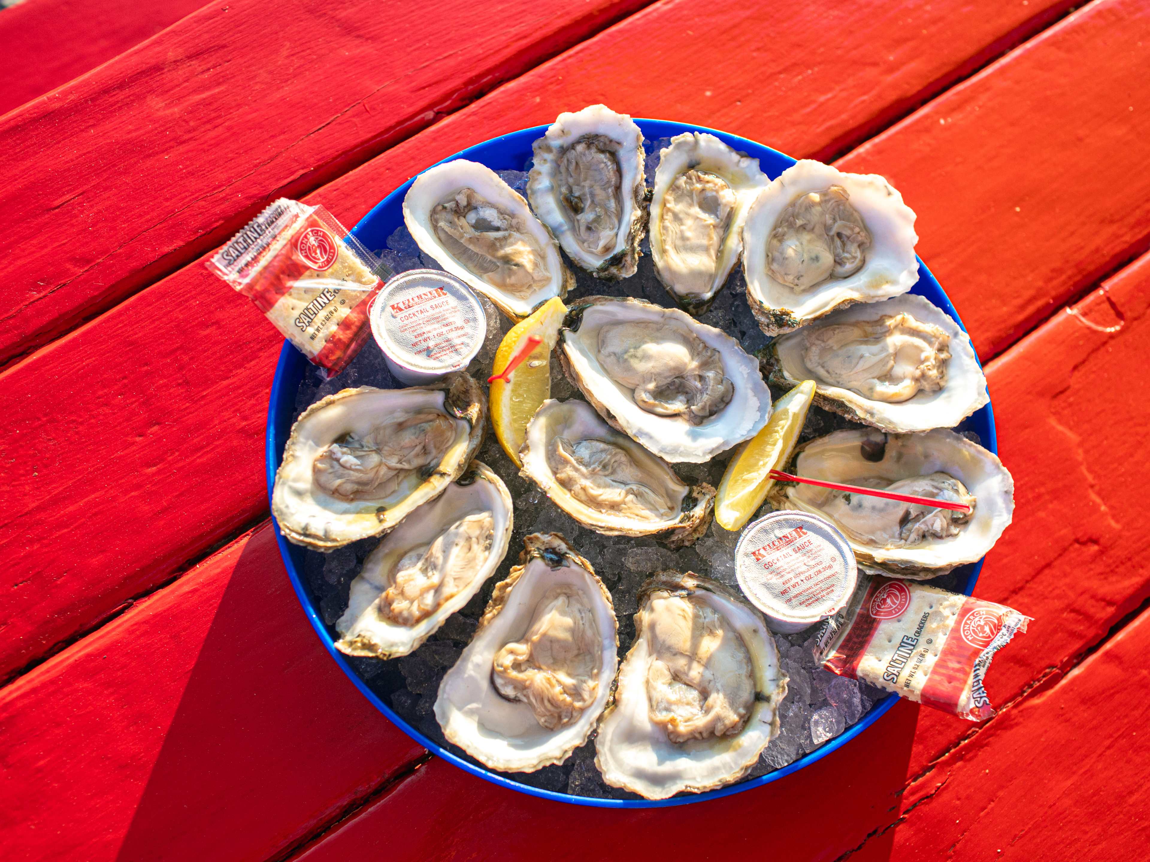 An overhead shot of oysters on a red picnic table