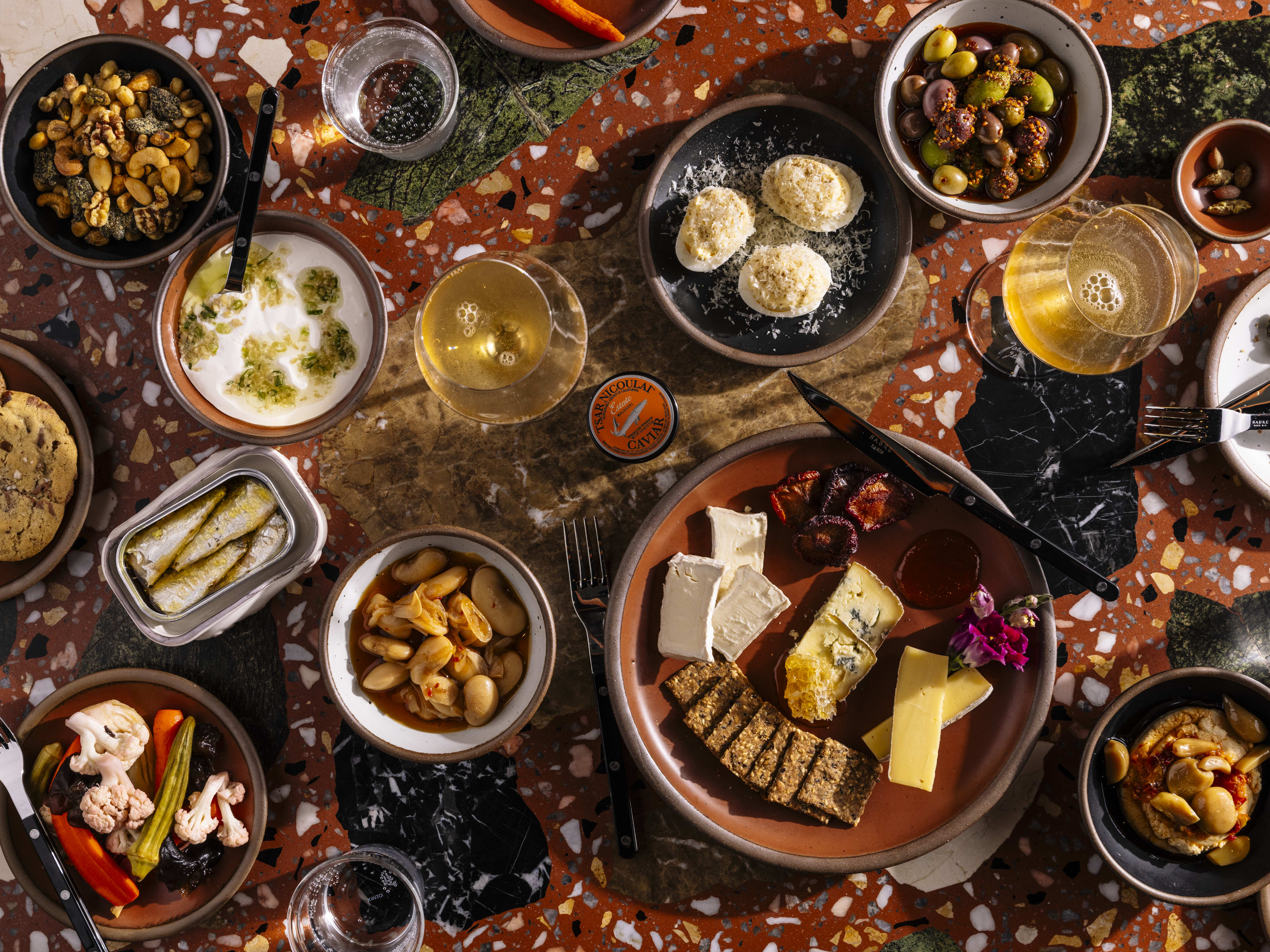 Small plates with tinned fish, cheese, deviled eggs, and olives.