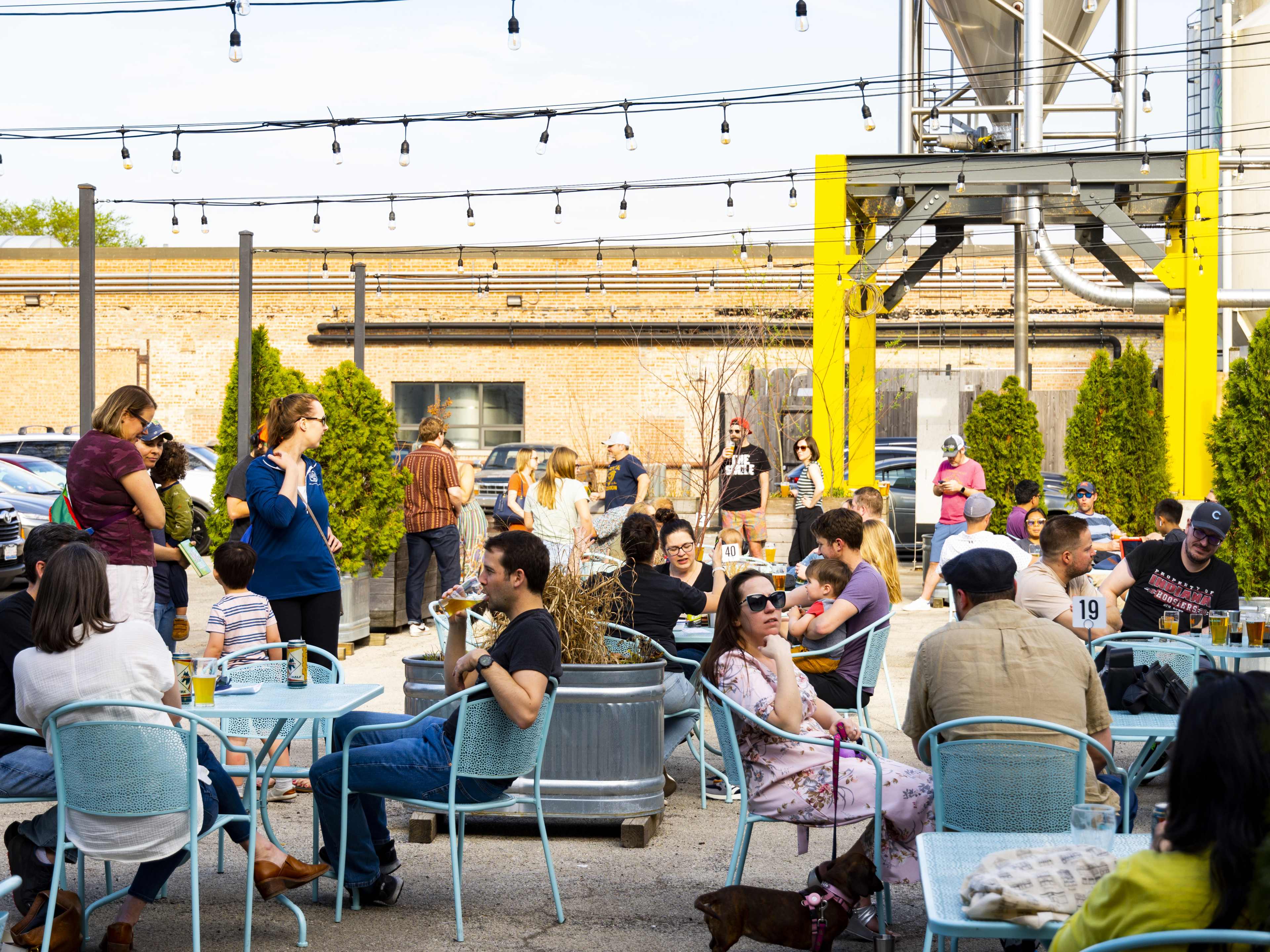 An outdoor beer garden with tables full of people.