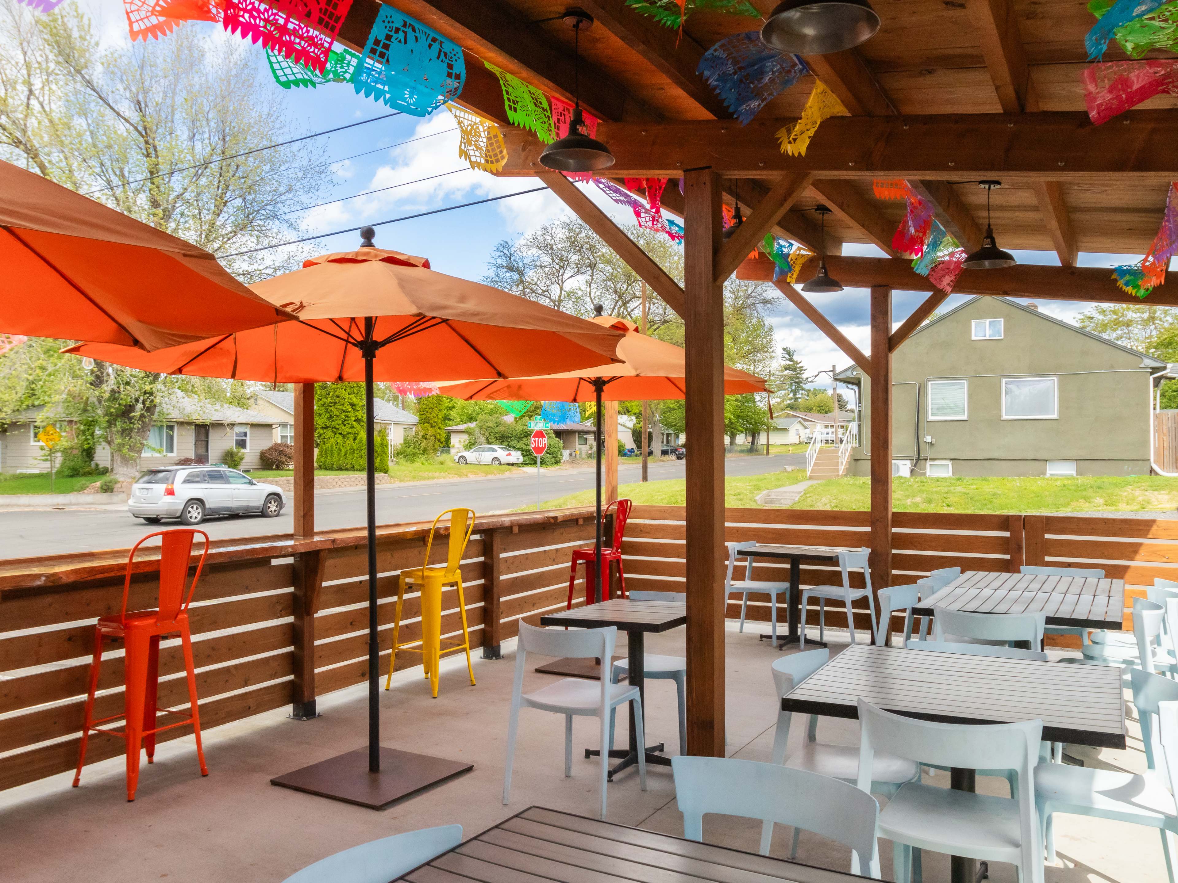 Patio with blue chairs and wooden tables