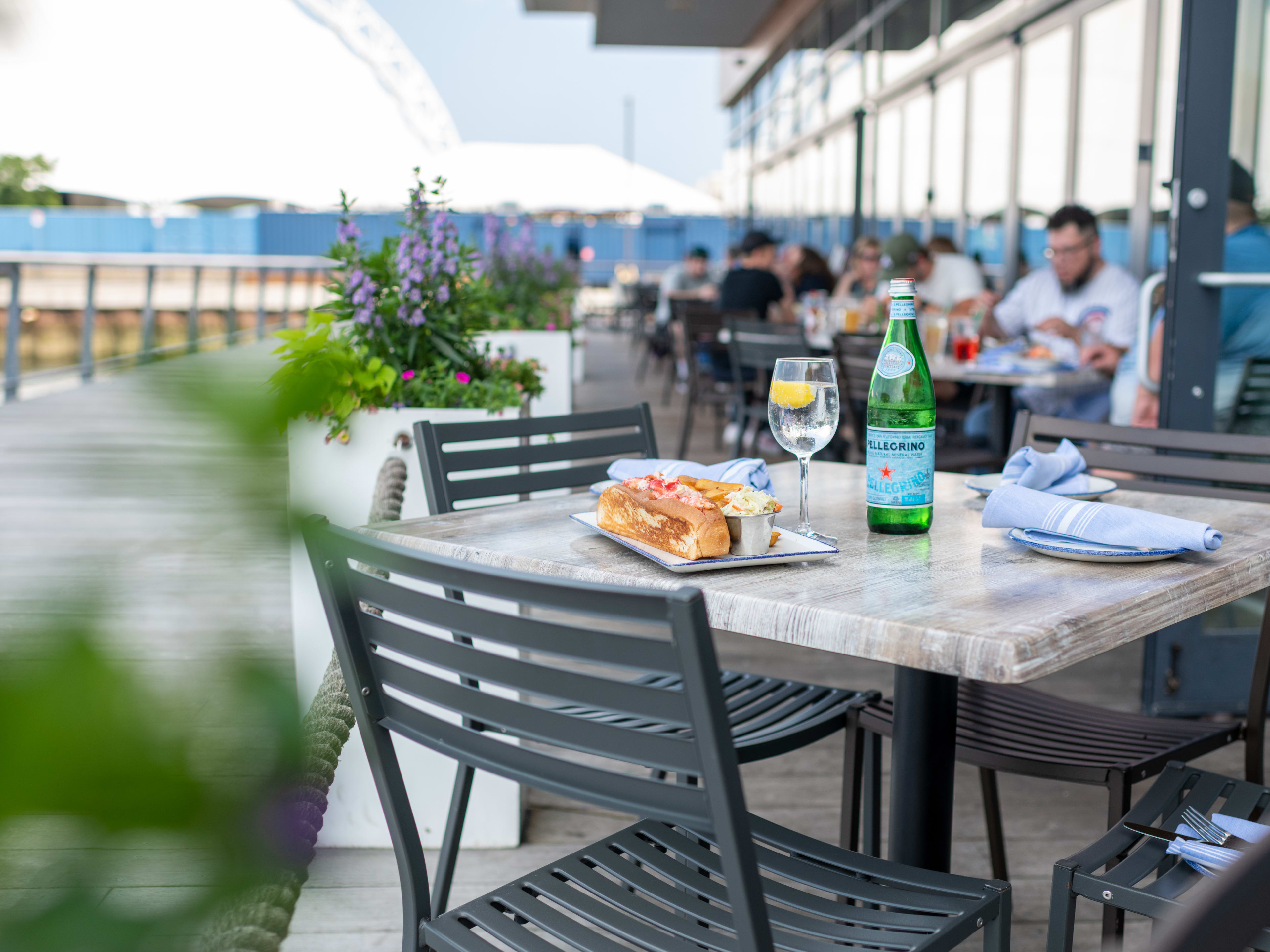 Lobster roll with bottle of San Pellegrino on outdoor table at Legal Harborside