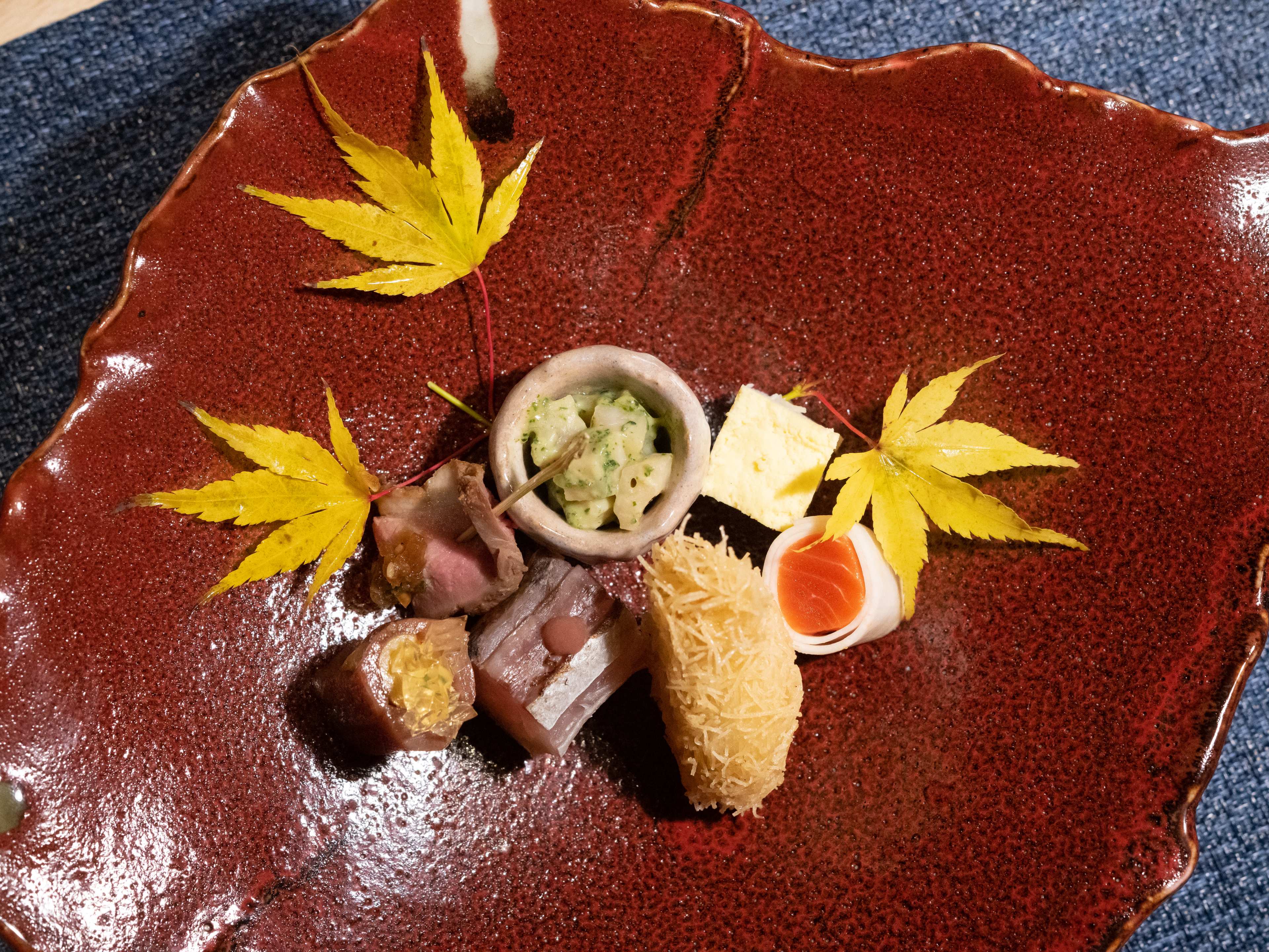 ceramic dish with tiny amuse bouche and leaves