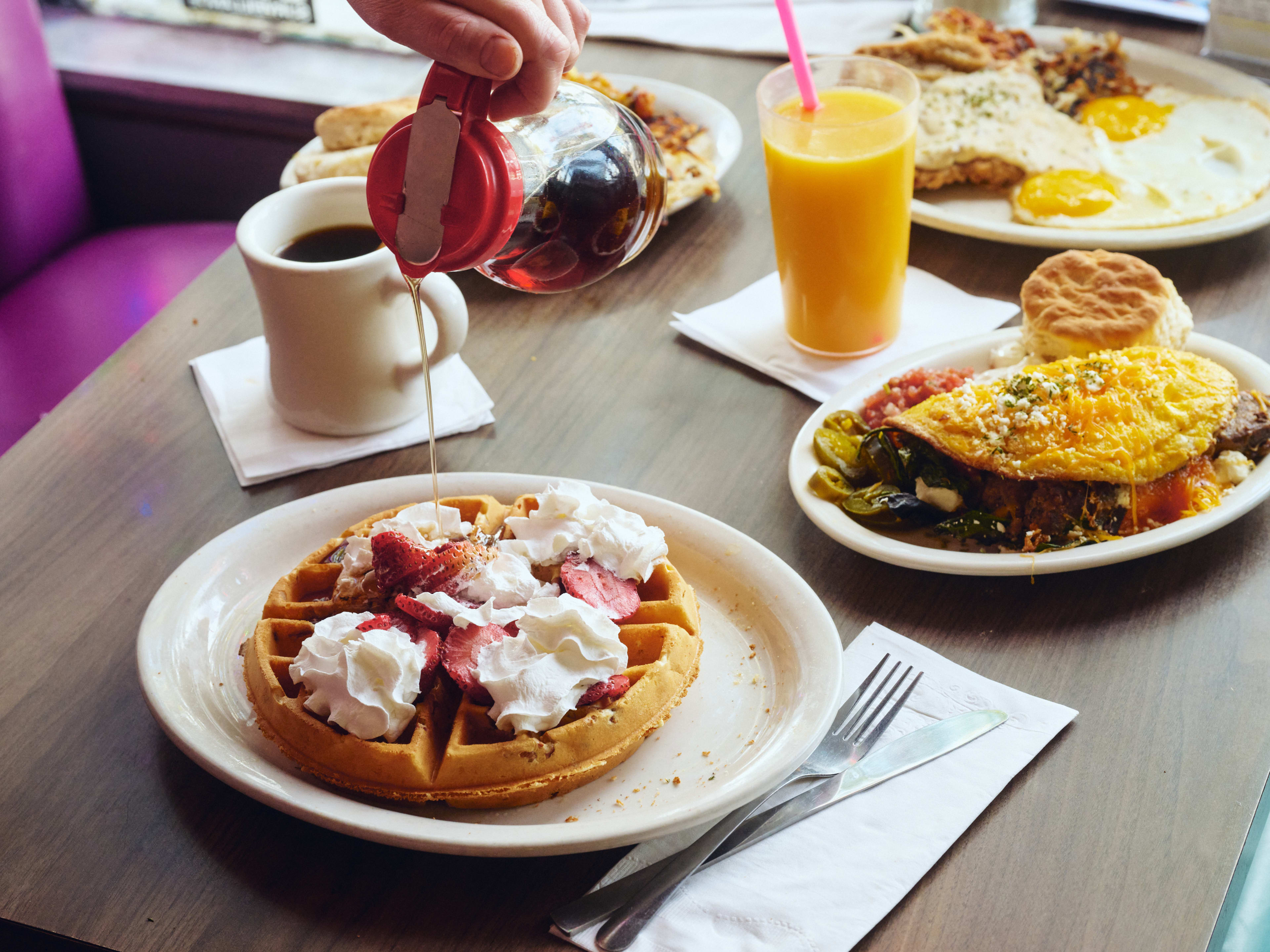 Spread of breakfast dishes and juice at Slim Goodies Diner