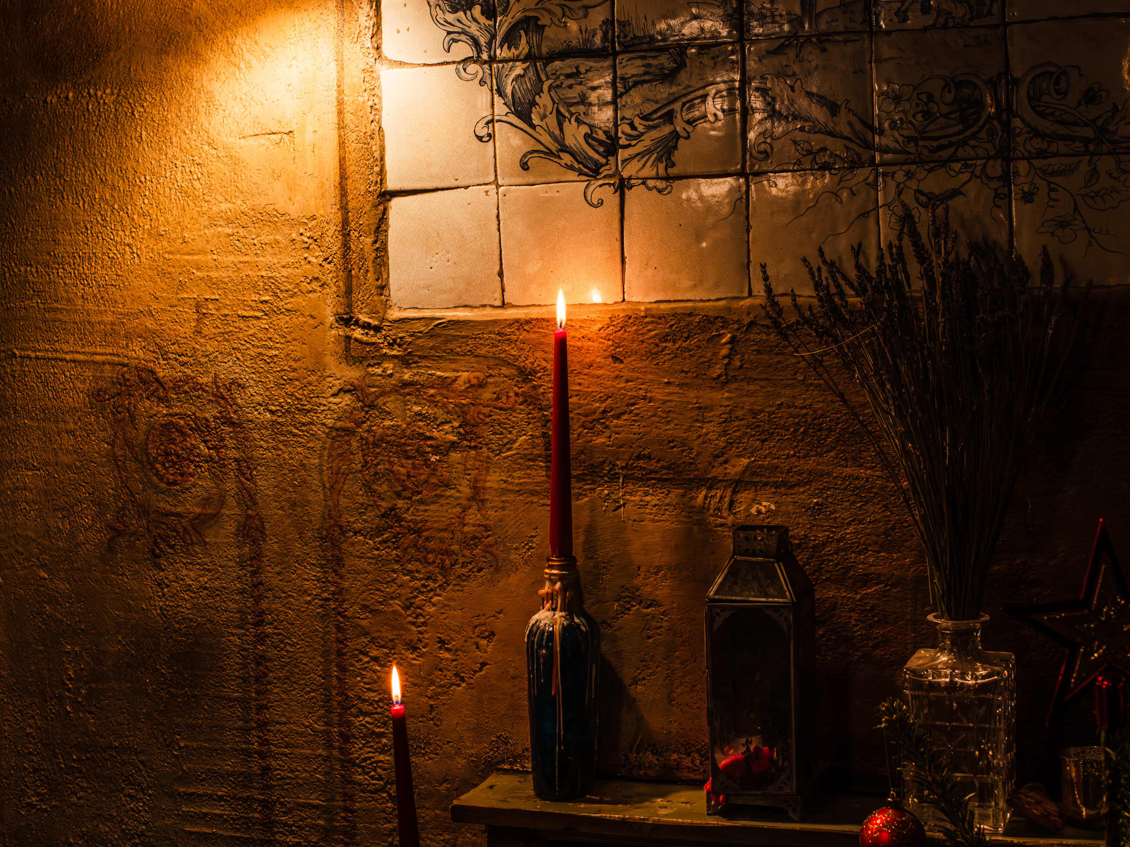 A candlelit shelf inside of The Holy Tavern.