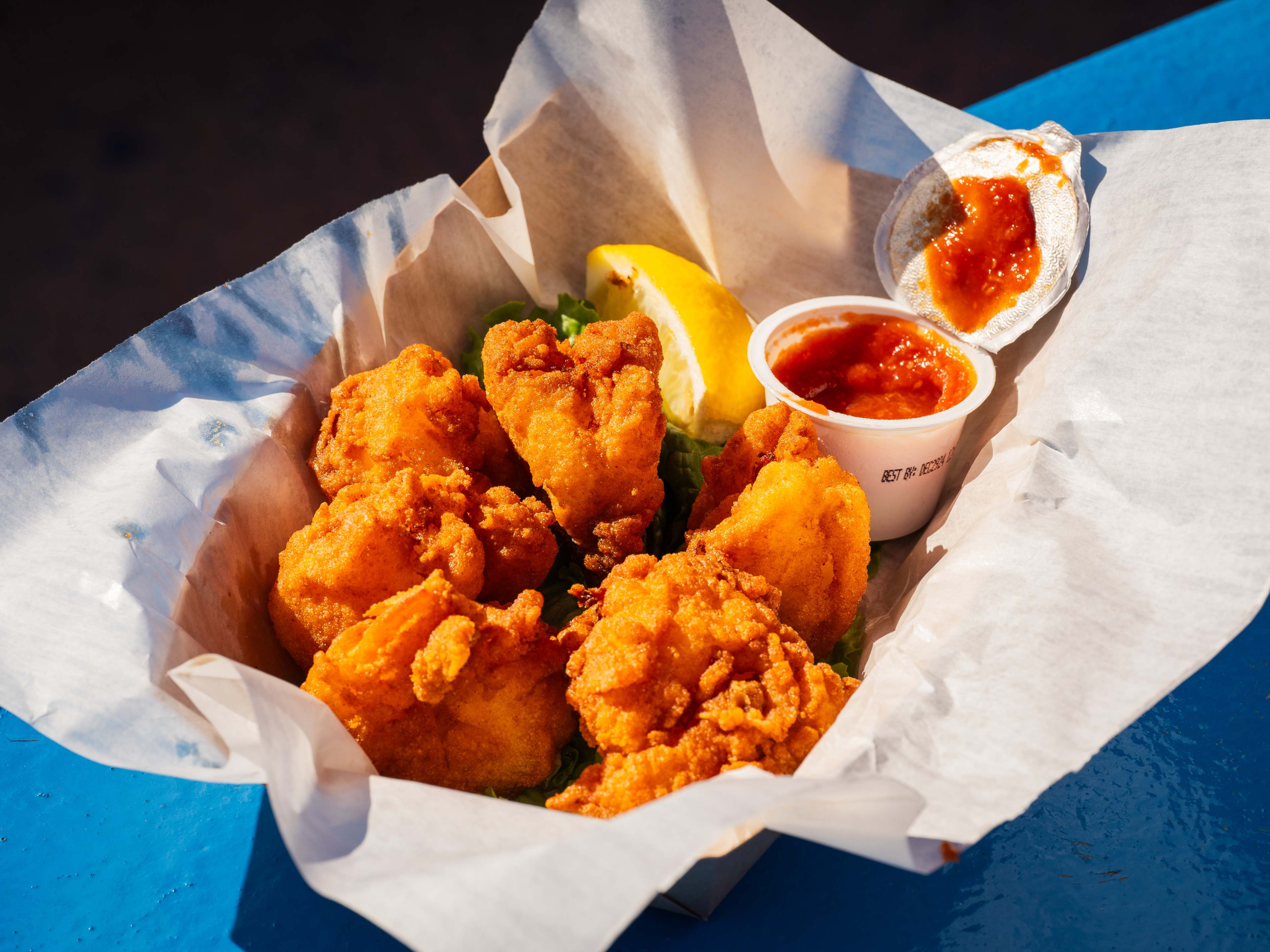 A plate of fried seafood on a blue picnic table