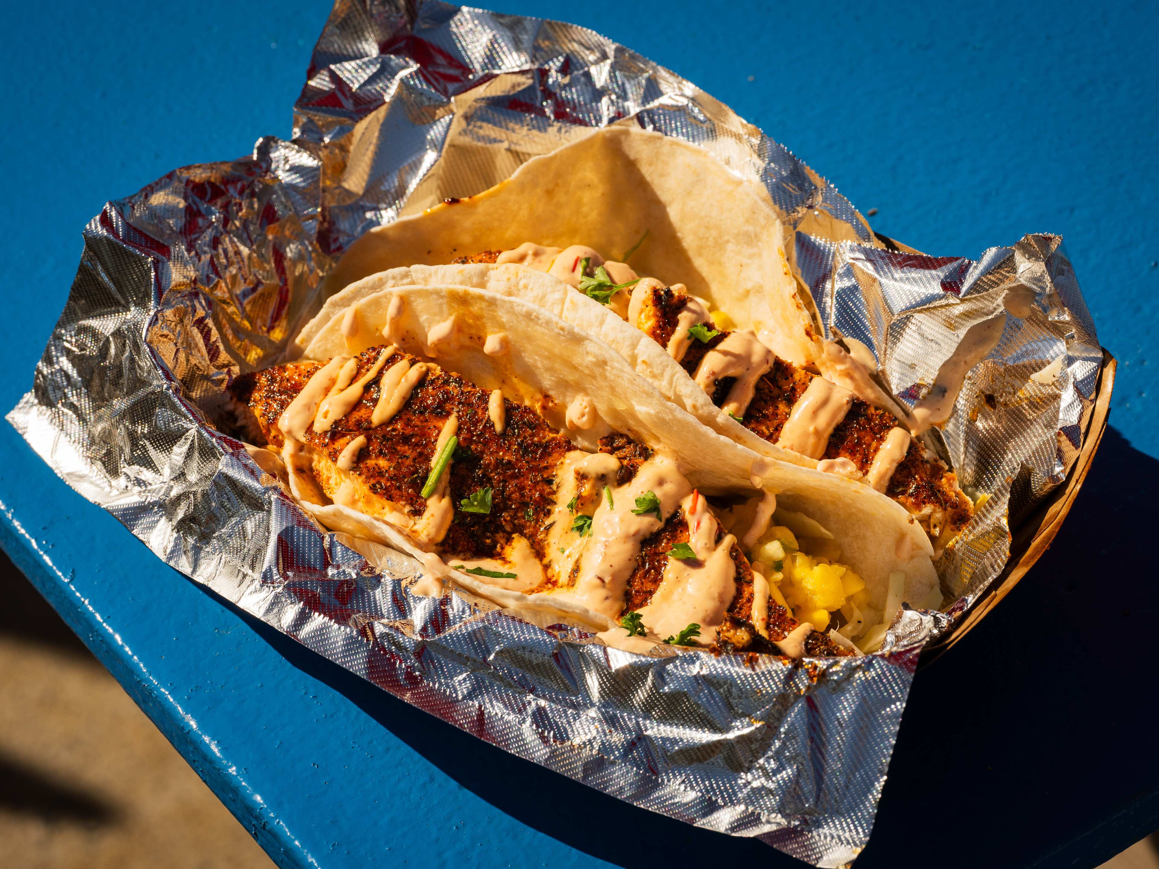 A plate of tacos on a blue picnic table