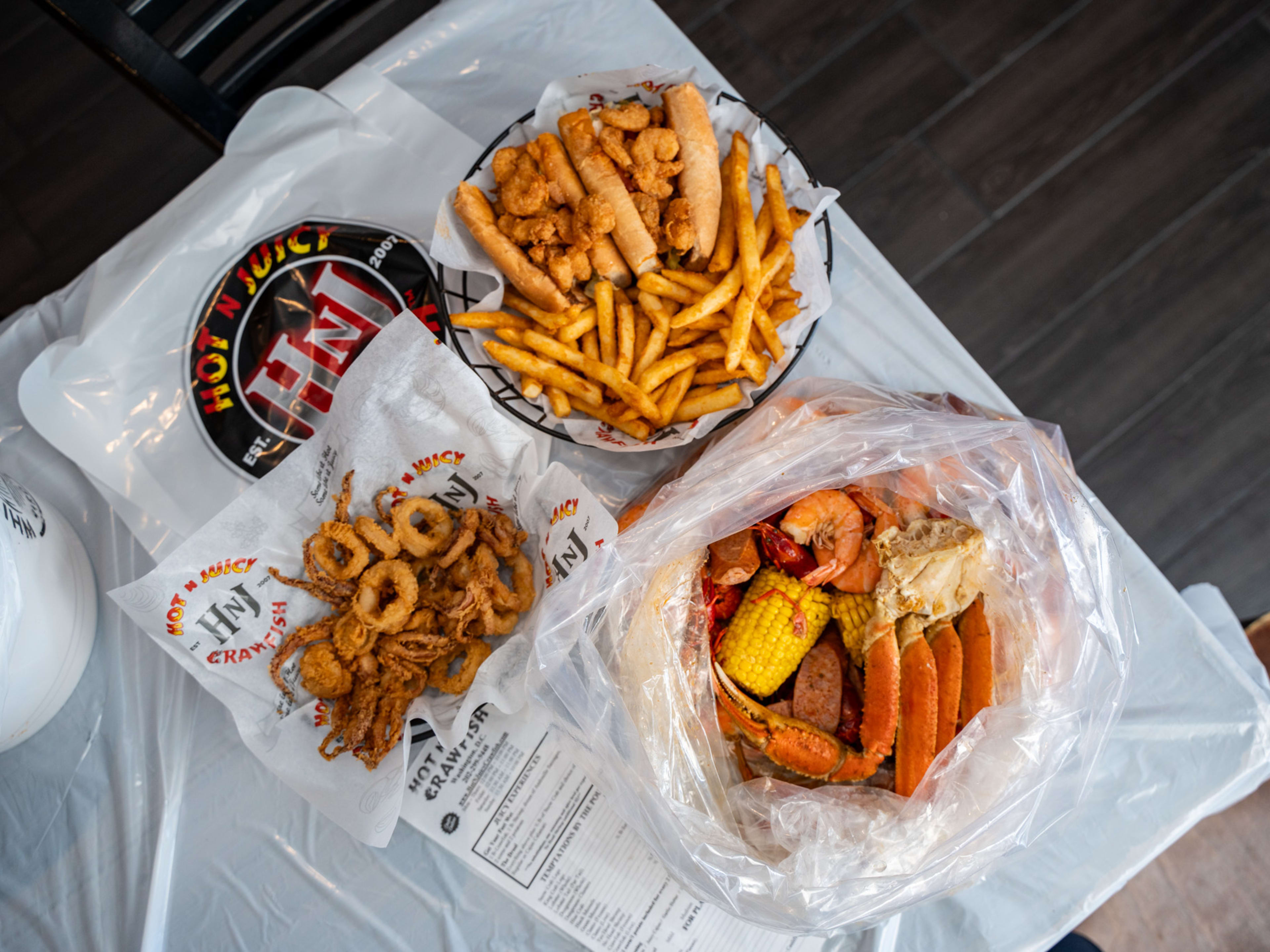 spread of seafood such as calamari crab legs corn fries and a shrimp roll