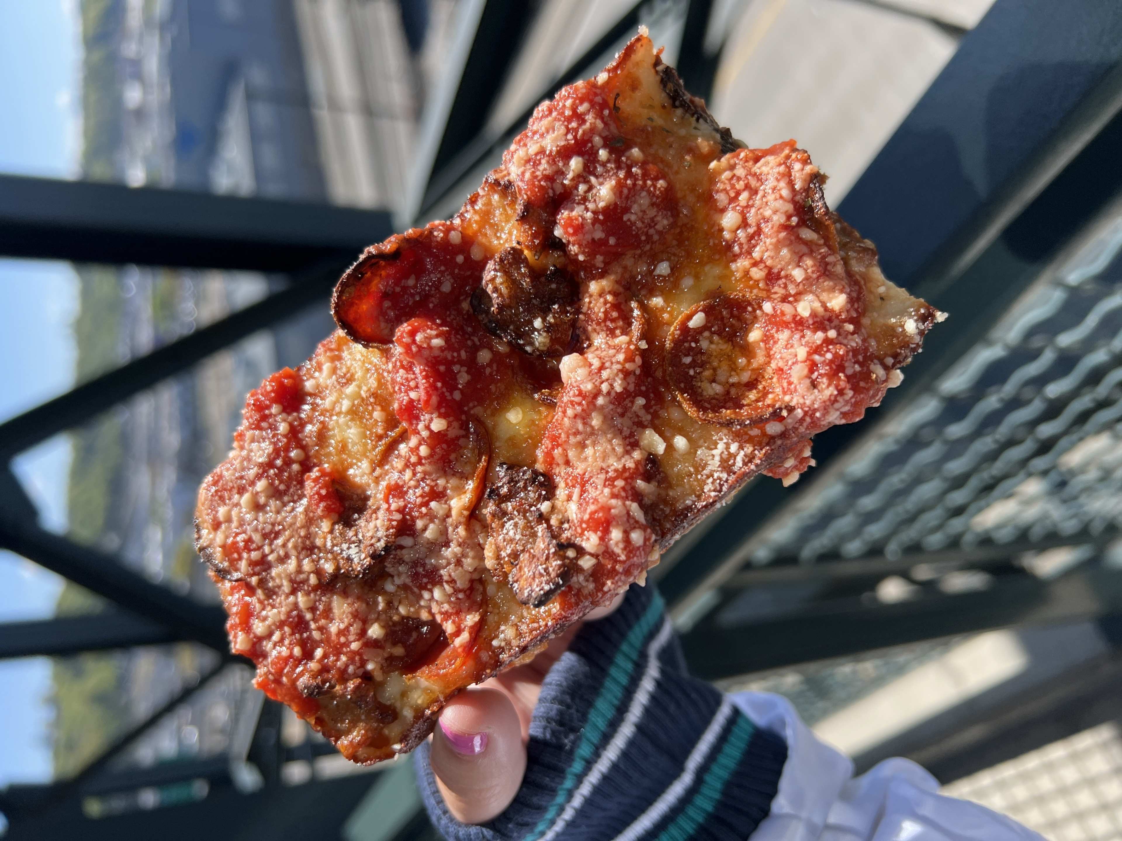 Detroit-style pizza slice with pepperoni and sausage