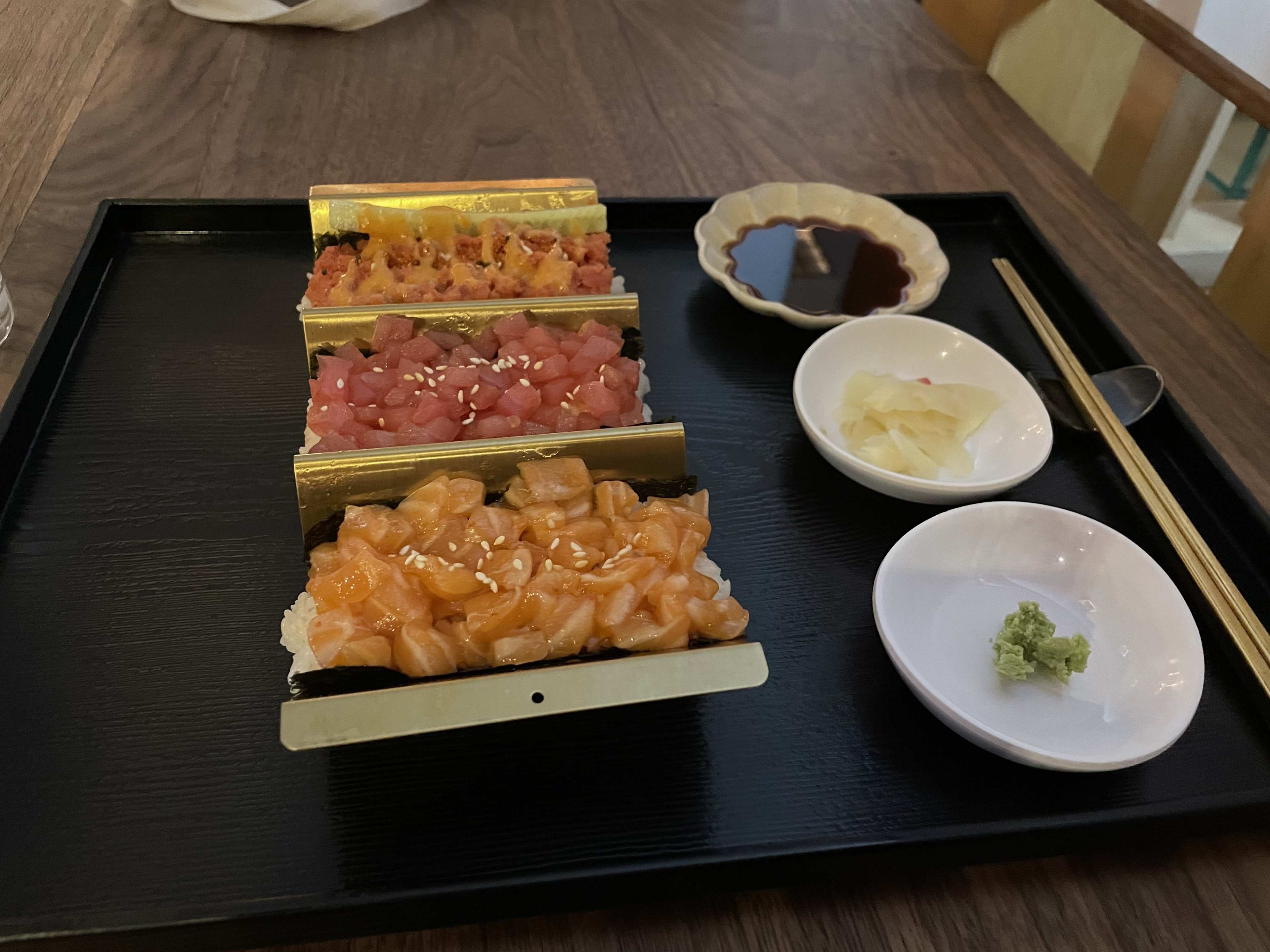 a trio of handrolls with salmon, tuna, and spicy tuna