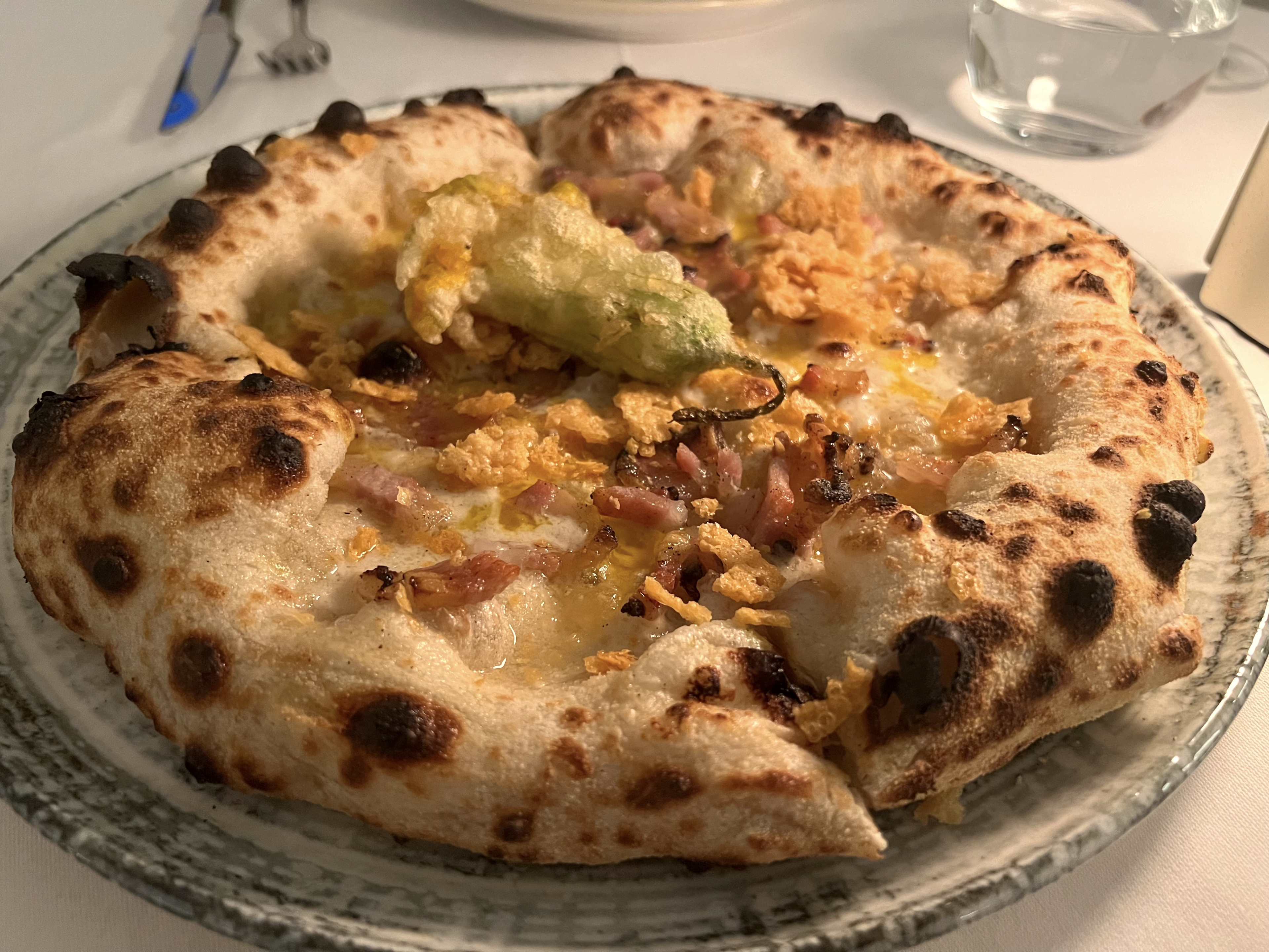 A fluffy pizza on a glass plate.