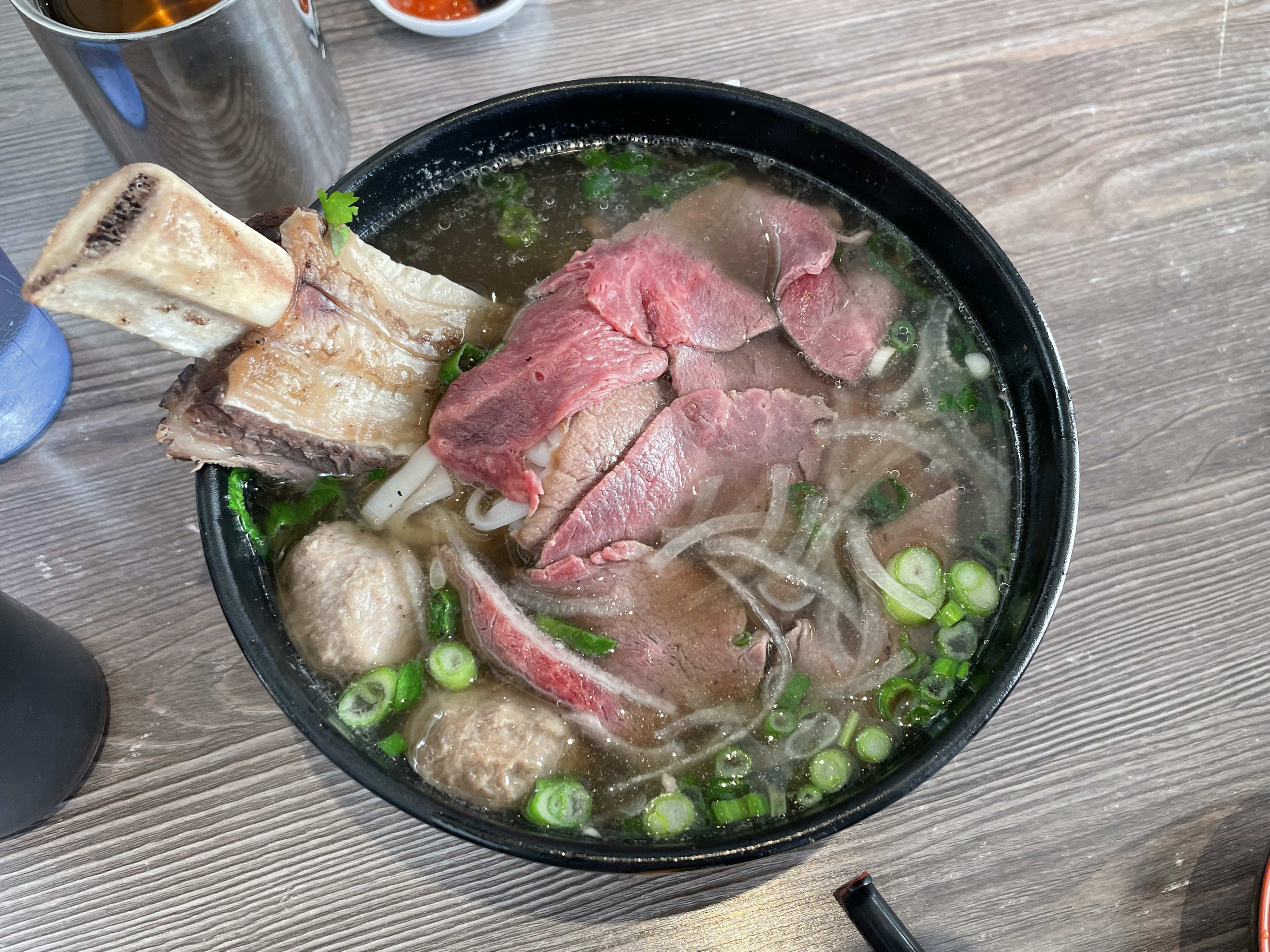 noodle soup with massive piece of beef on the bone in it