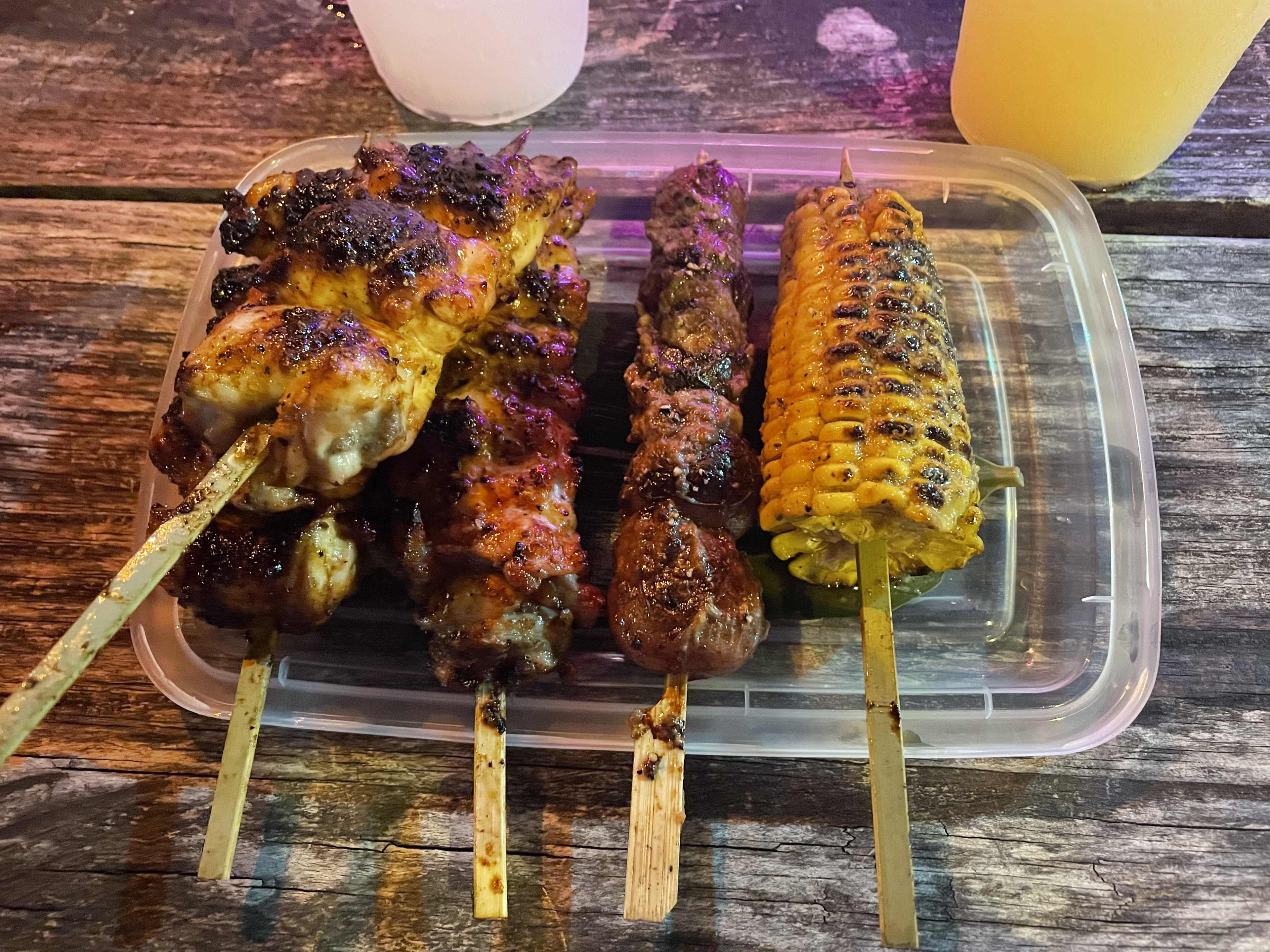 skewers of grilled meat and corn