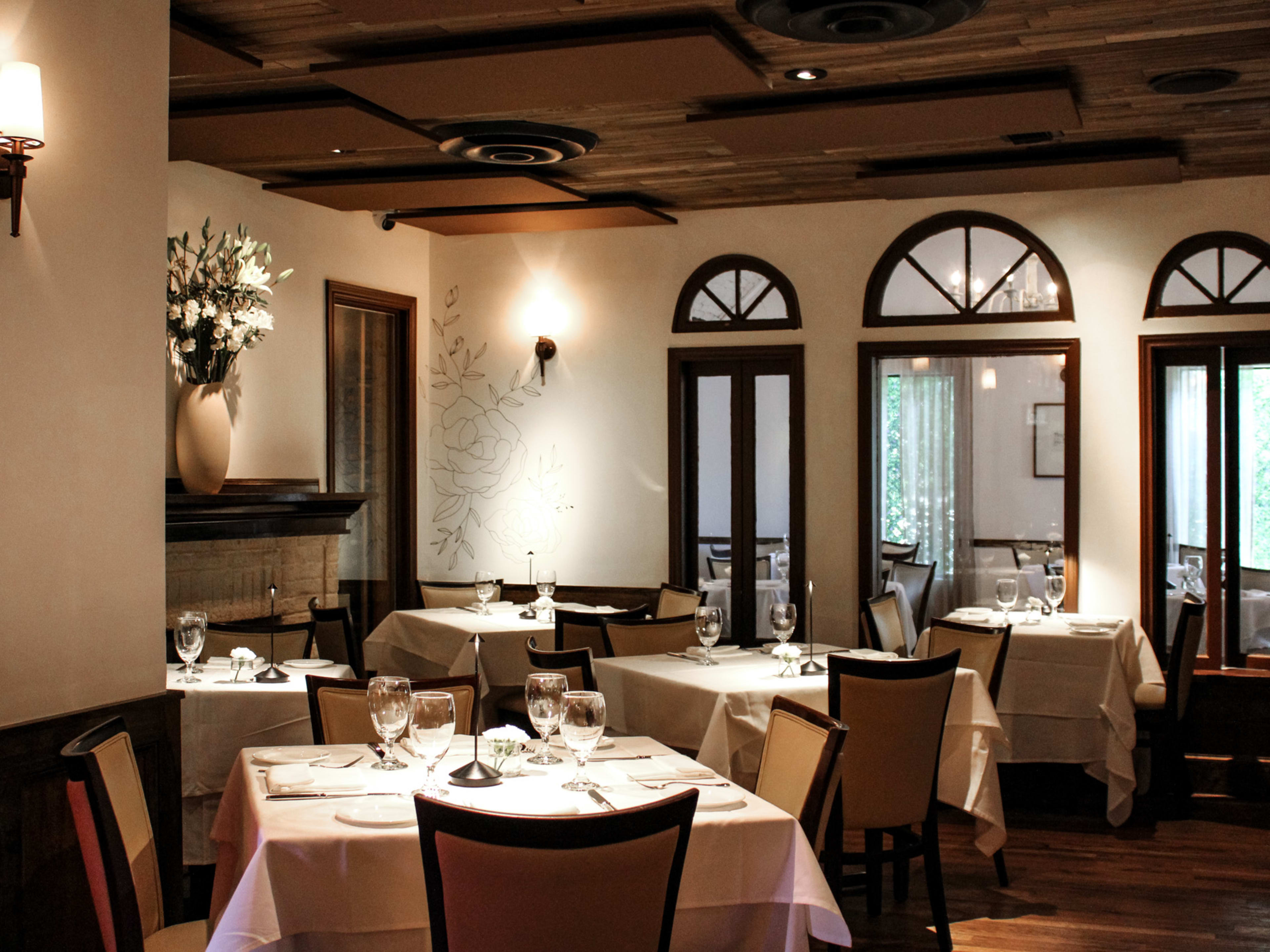 Italian restaurant dining room with white table cloths and arched windows