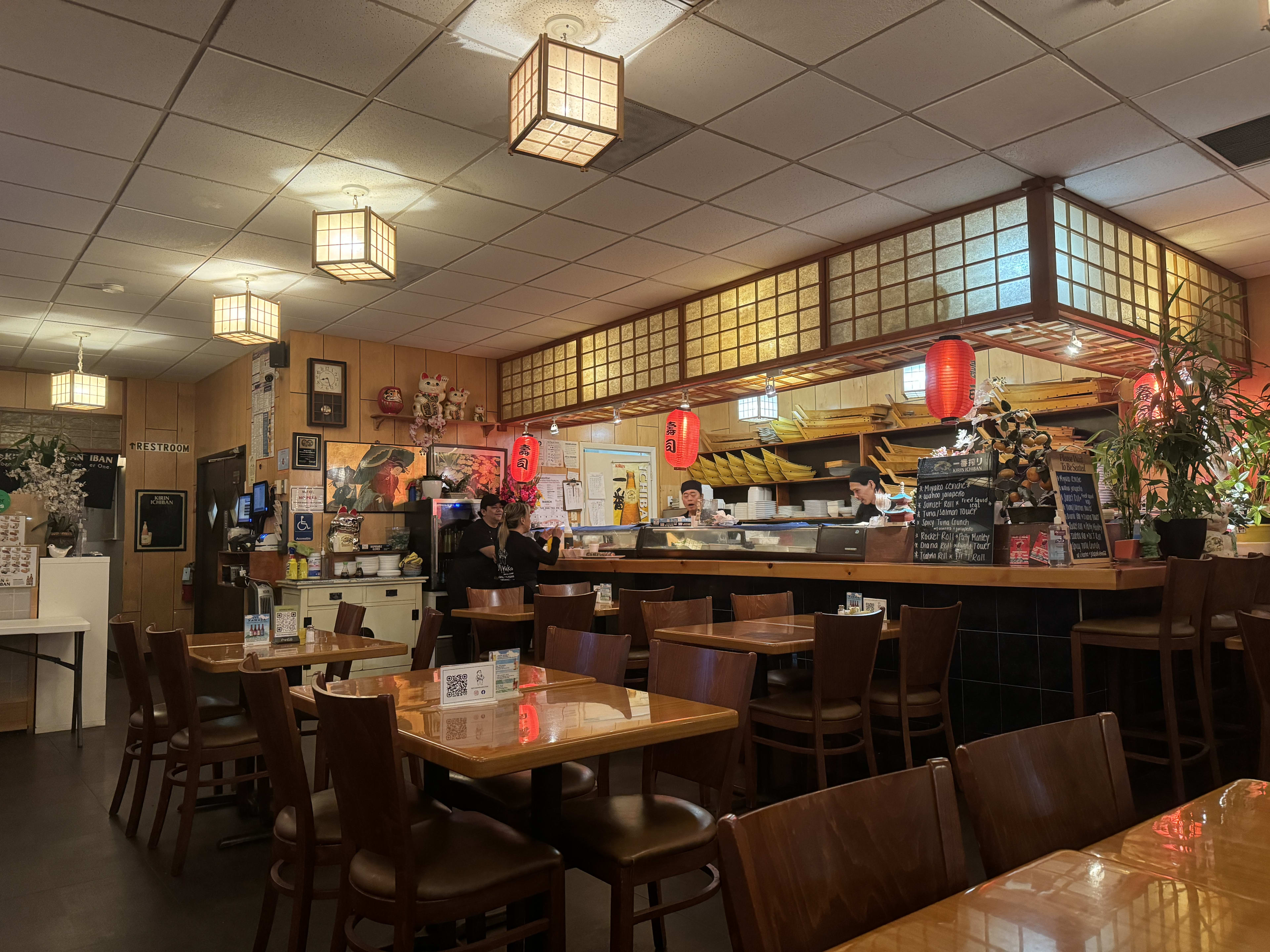 Interior of Japanese restaurant with red lanterns and sushi bar.