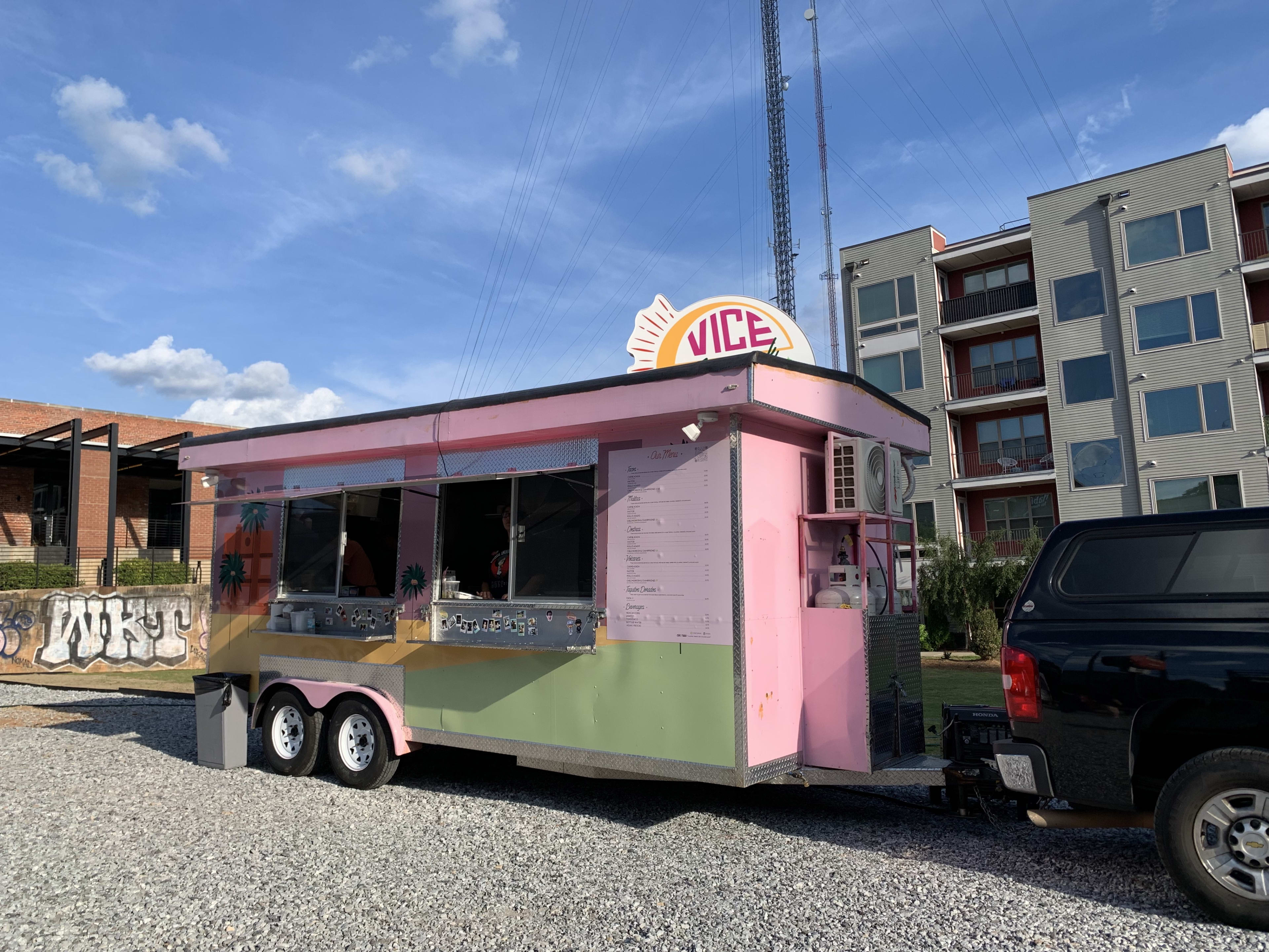 colorful taco truck hitched up to car