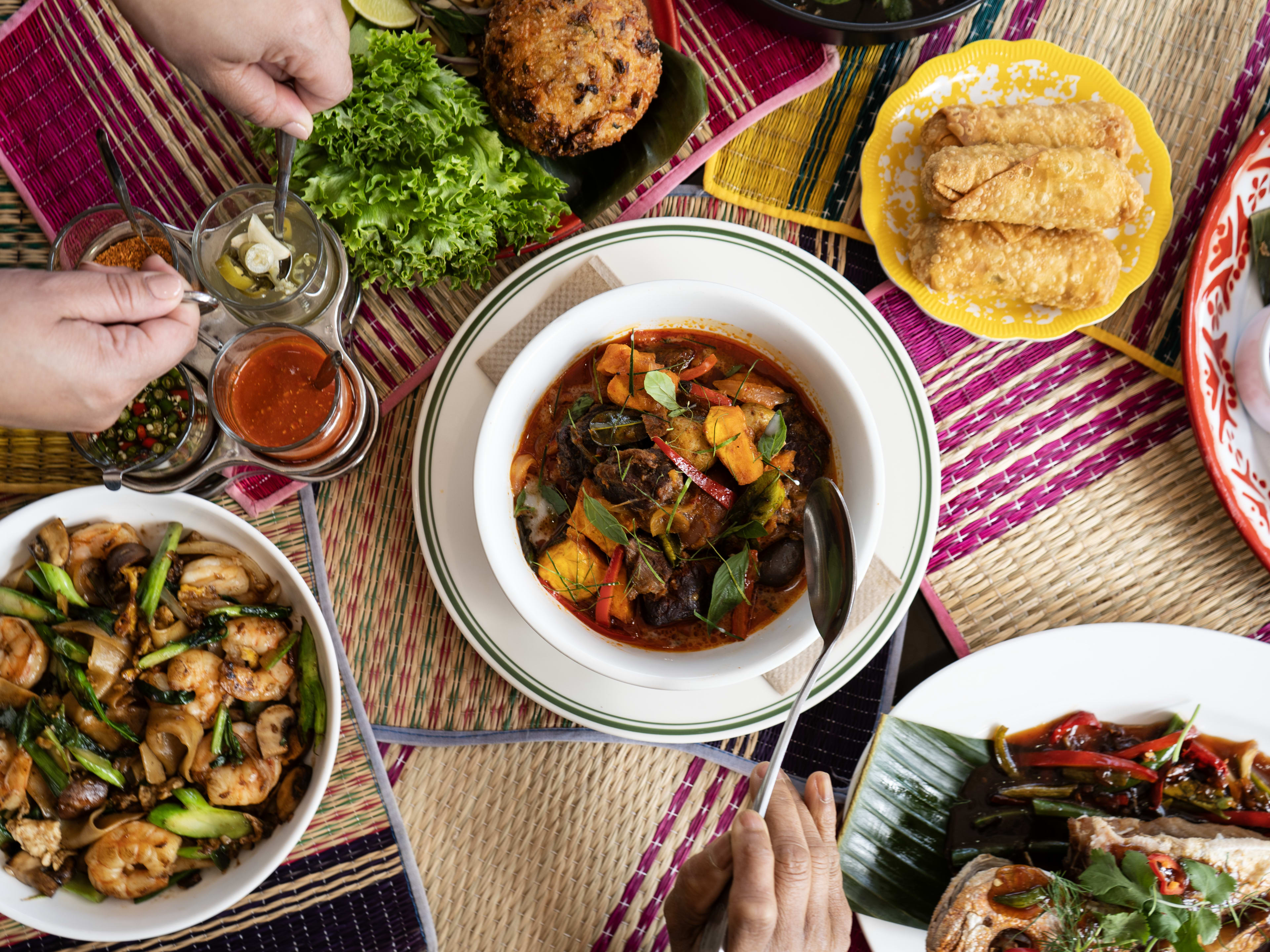 Spread of colorful Thai dishes including a whole roasted fish at International Market