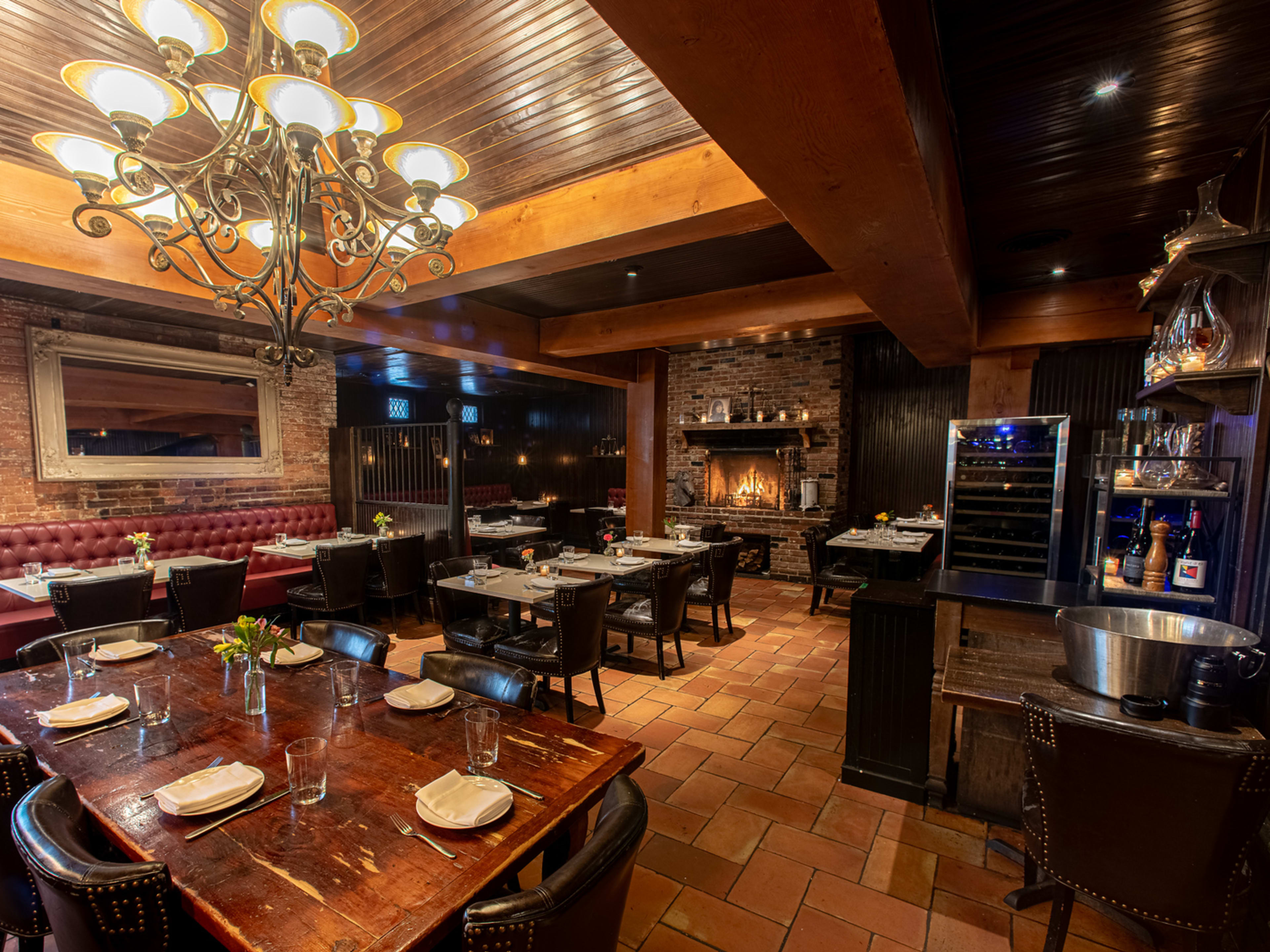 cozy brick walled restaurant interior with chandelier and set tables