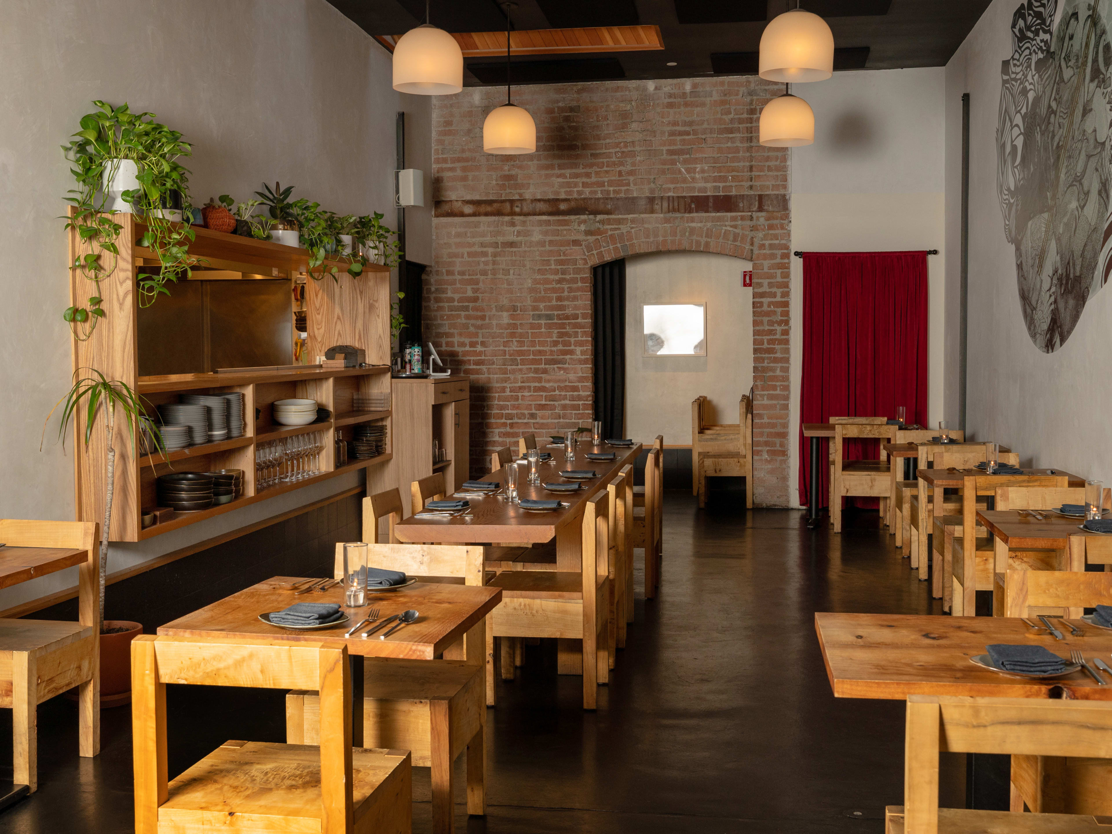 low-lit interior with exposed brick walls and wooden tables