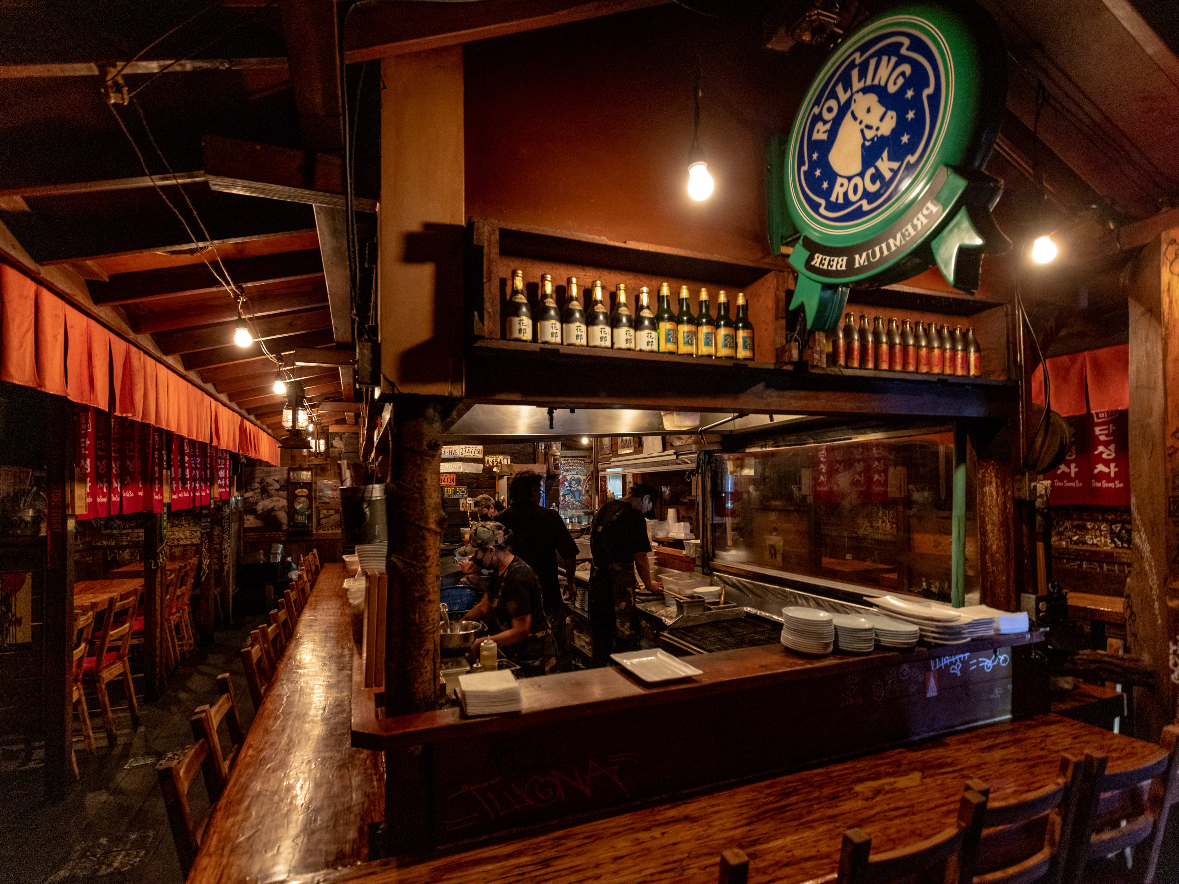 The dimly lit interior of Dan Sung Sa. There is a bar and individual booths.