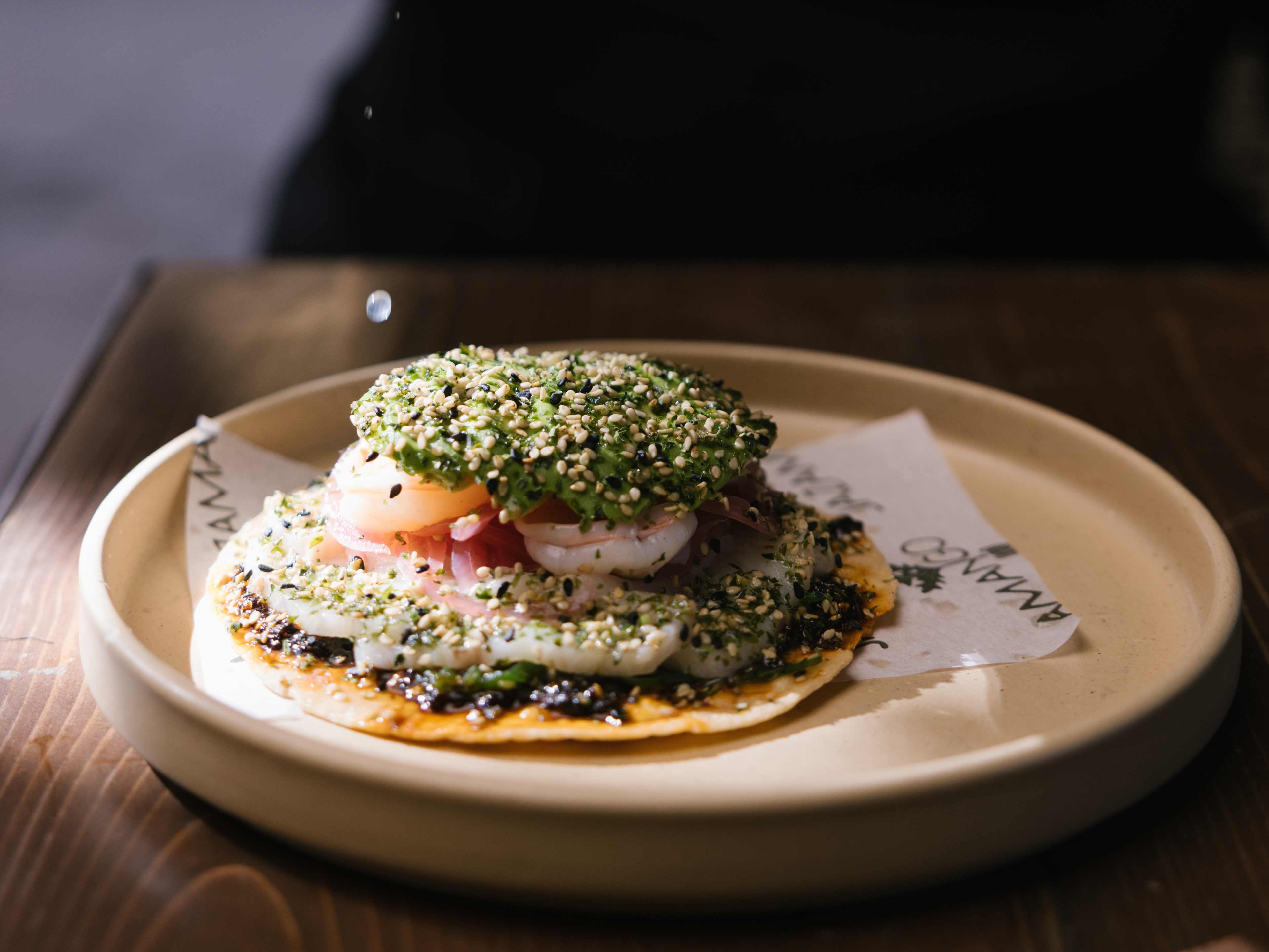 Spicy fish tostada topped with sesame seeds at Jazamango