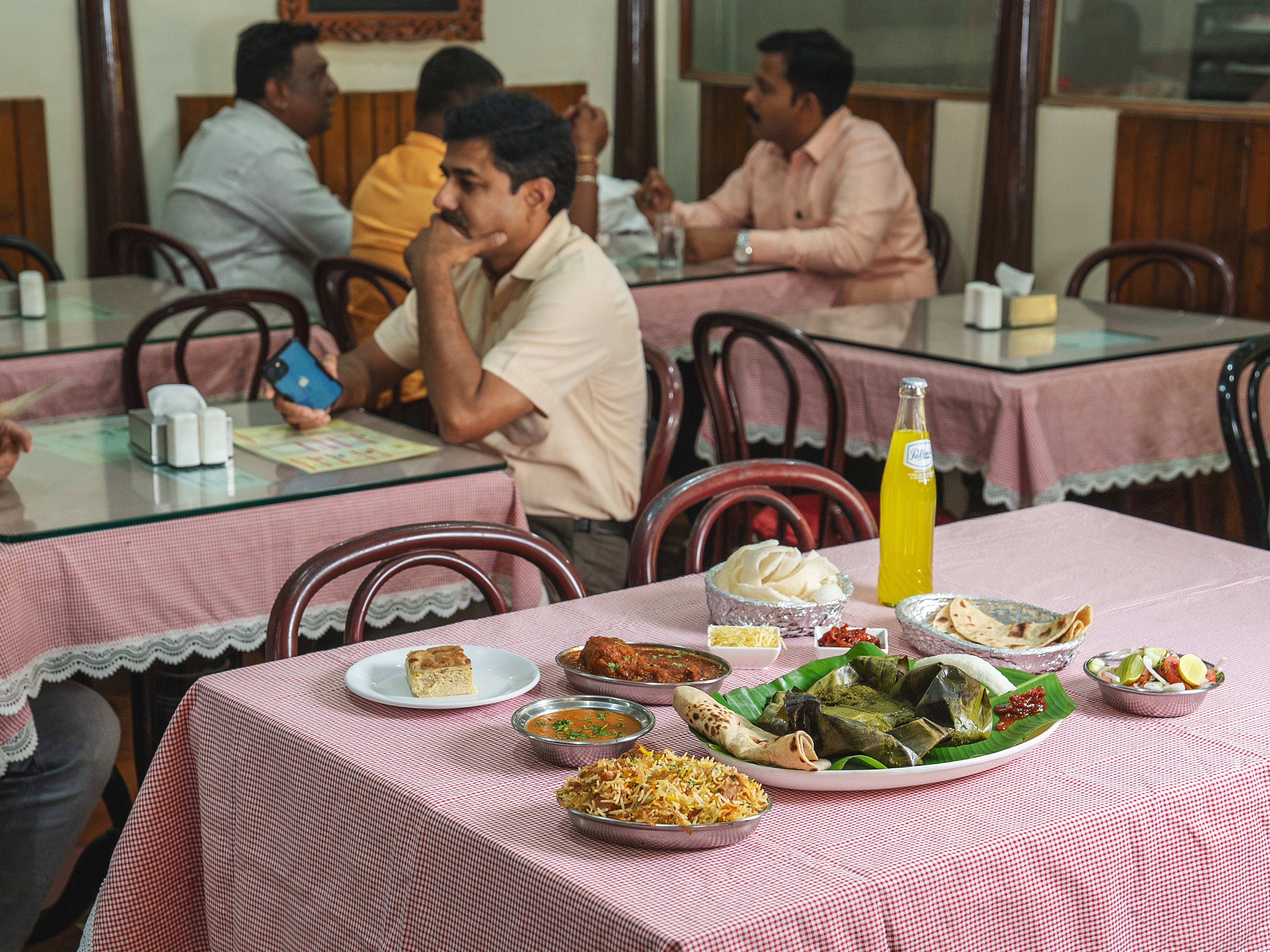 Lagan nu Bhonu spread on red checkered tablecloth at Jimmy Boy