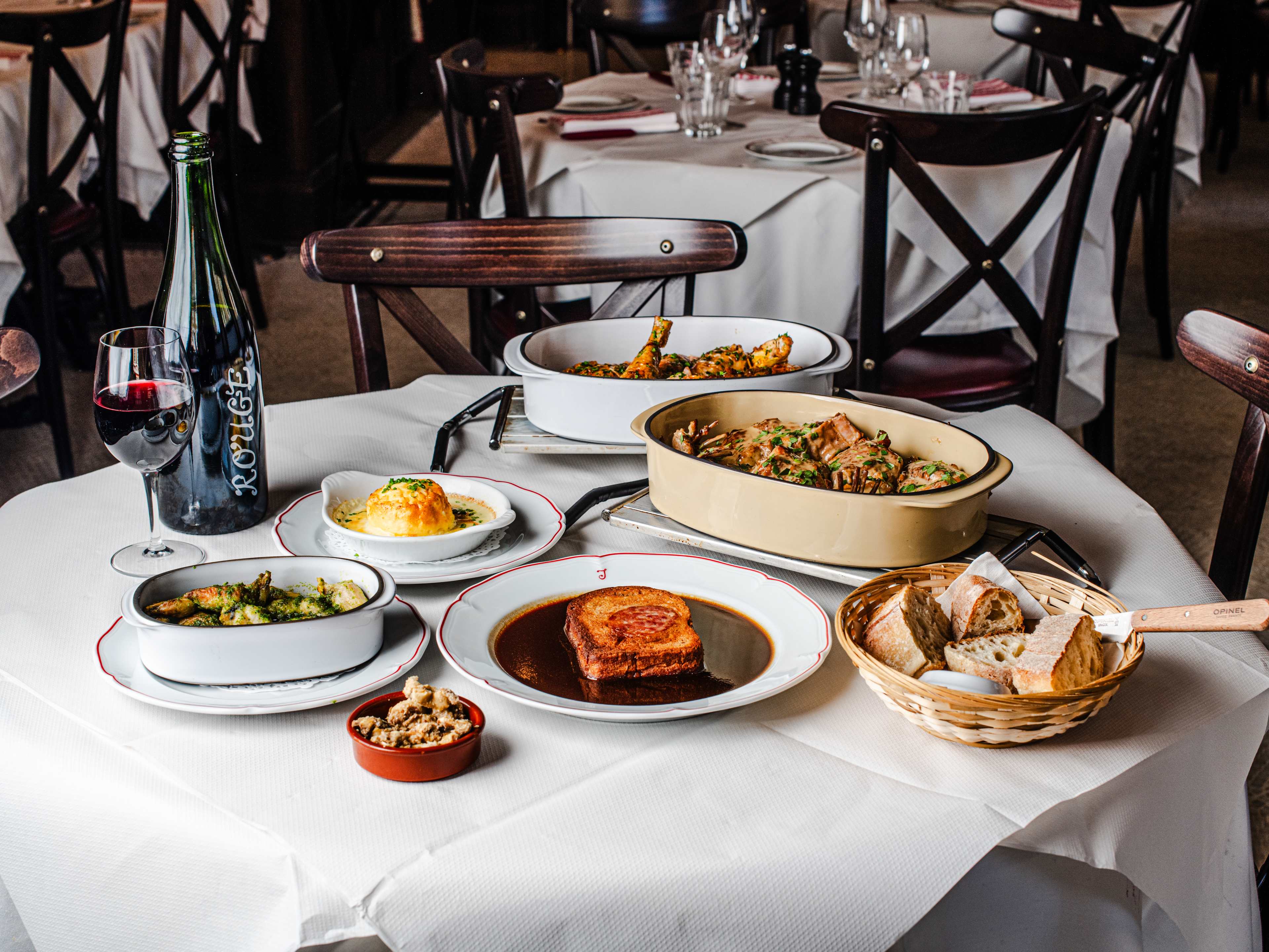 A spread of dishes from Josephine Bouchon on a table with a white table cloth.