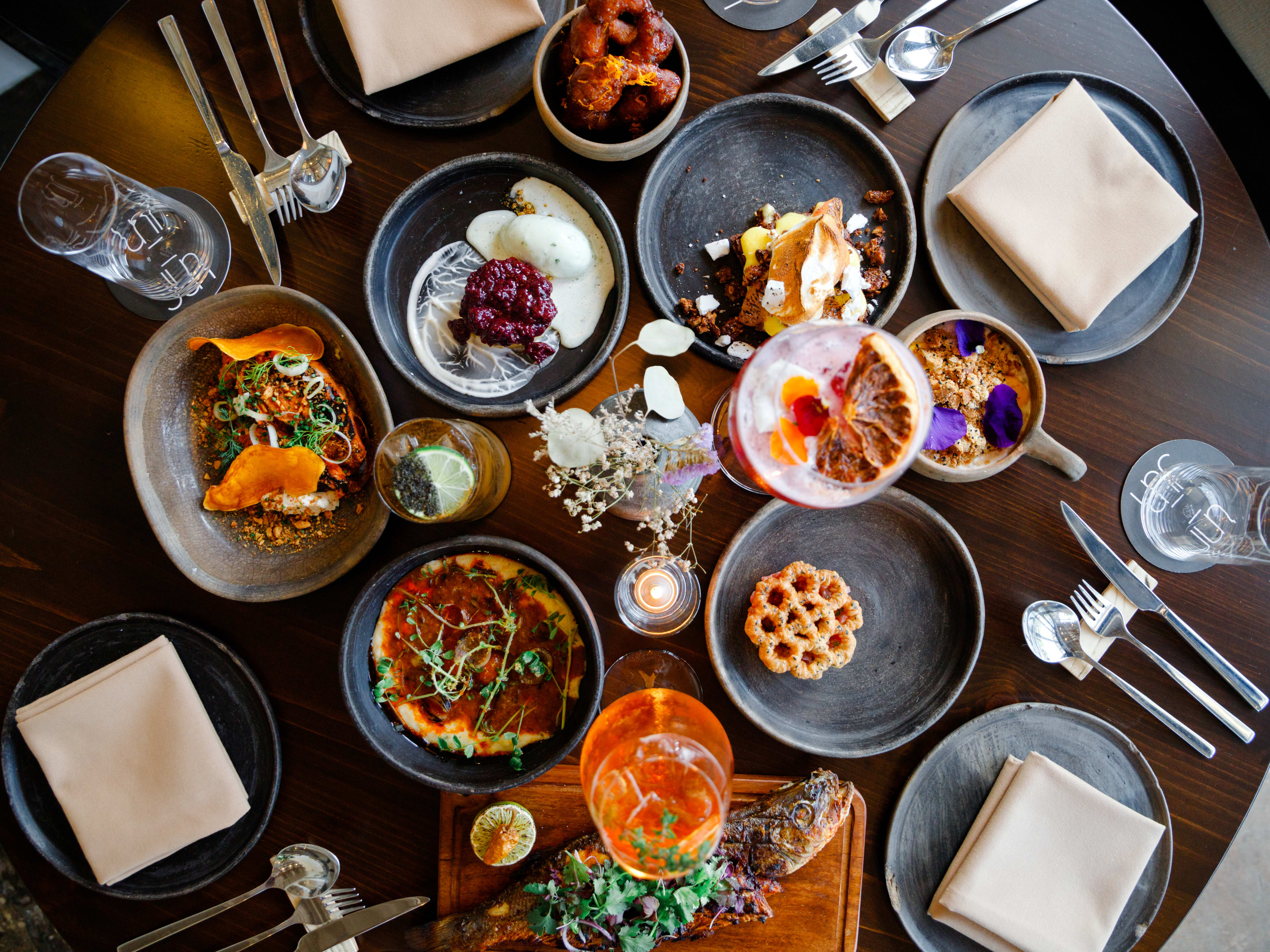 A spread of dishes from Jūn served on grey ceramic dishes.