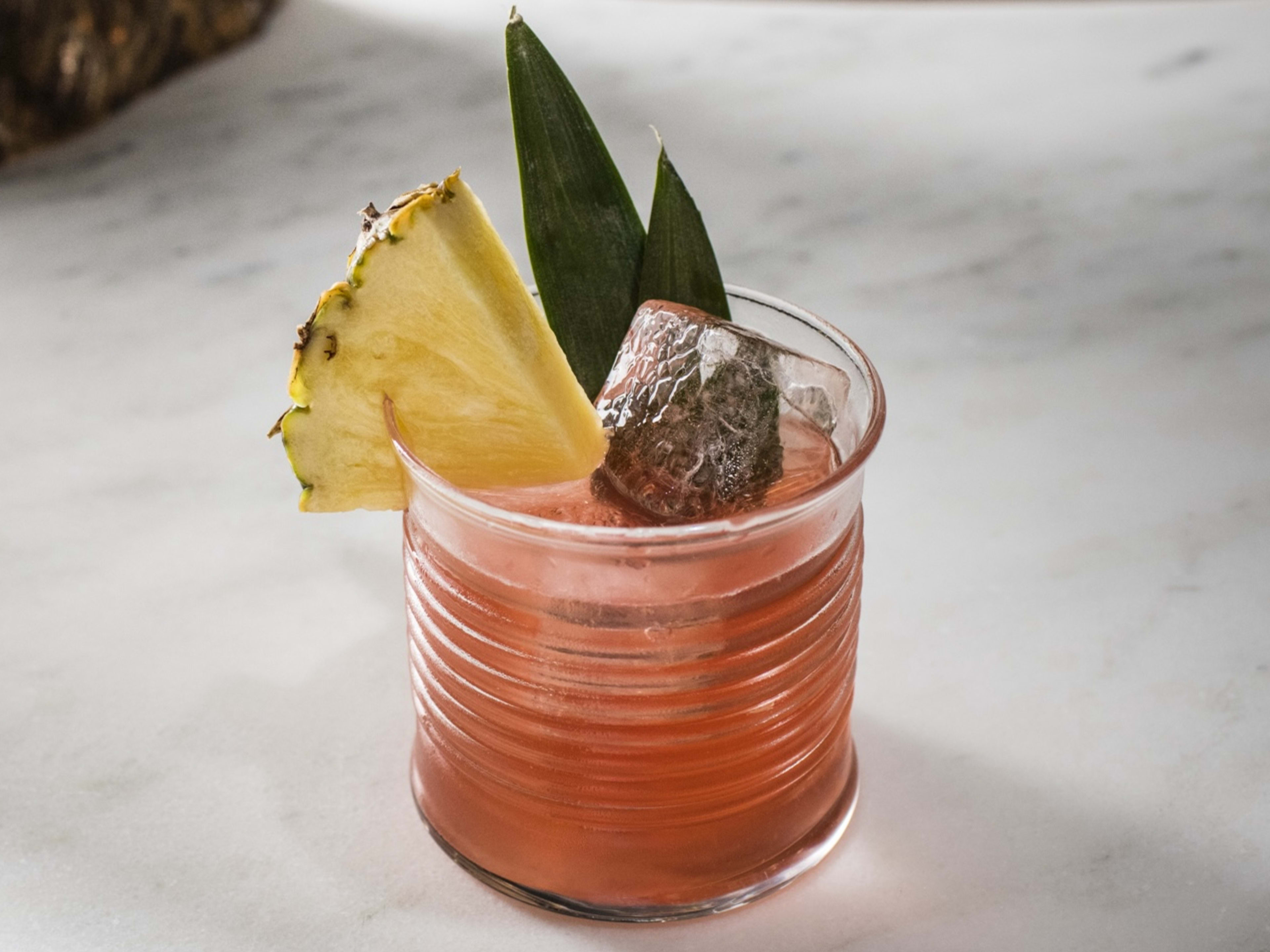 A cocktail garnished with pineapple from Jungle Bird.