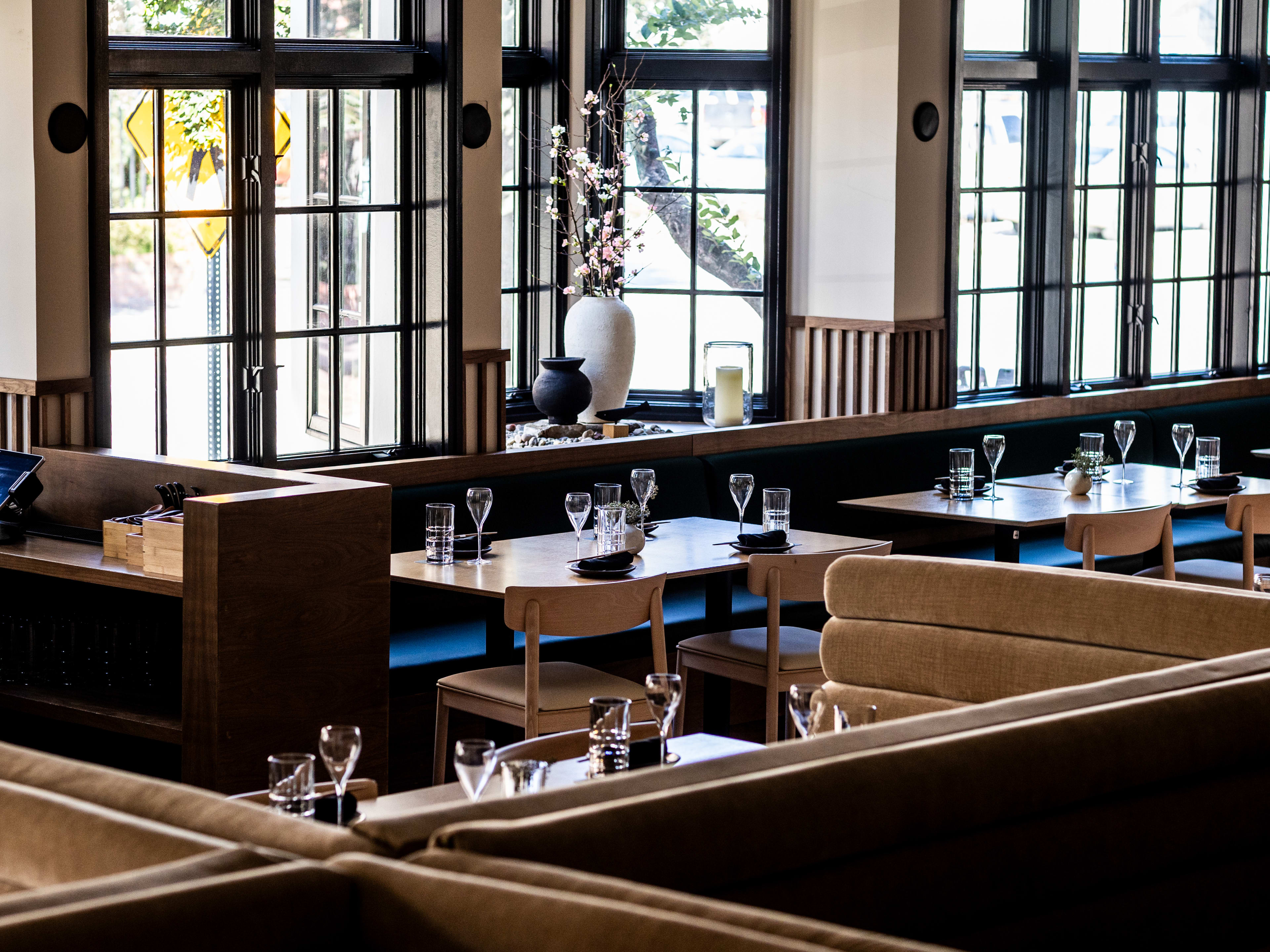 Japanese restaurant Katami interior with light wood, blue accents, and large windows.