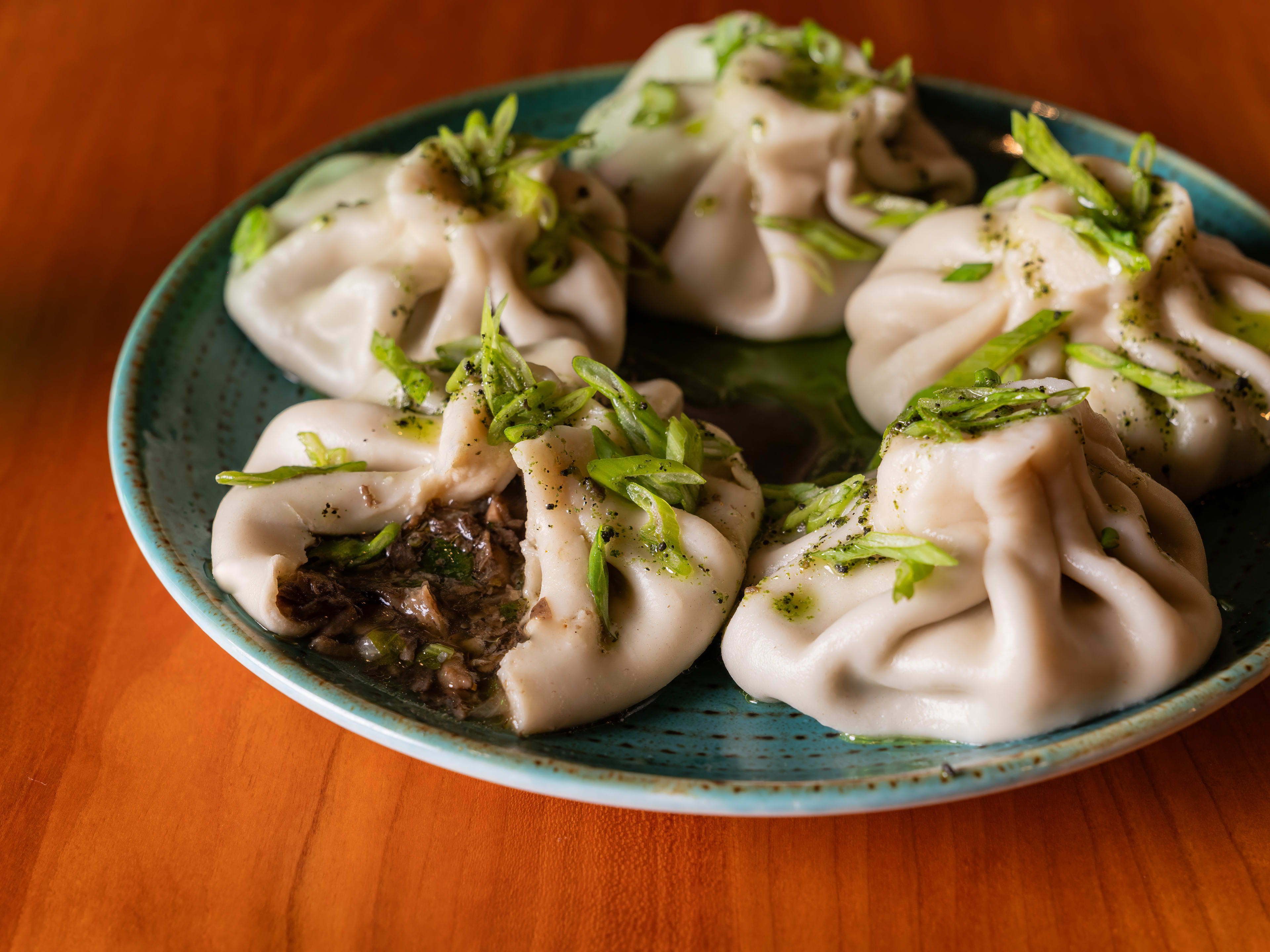 khinkali dumplings garnished with greens and filled with meat