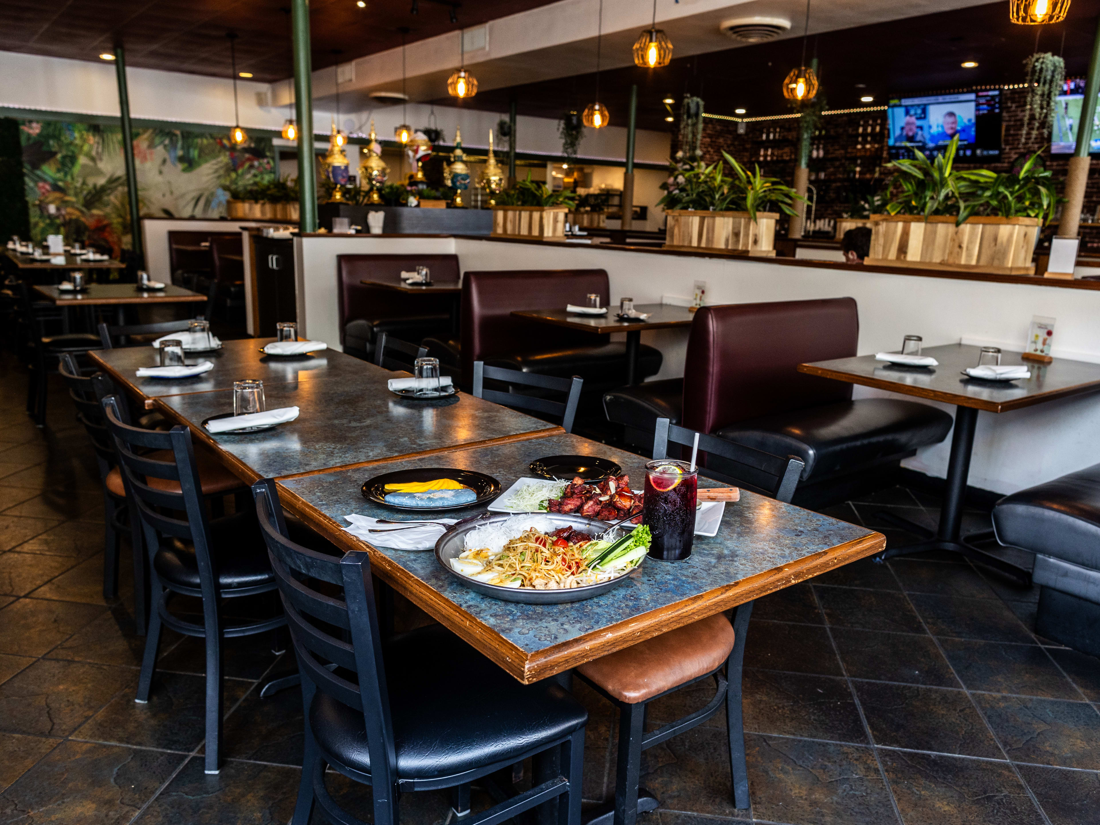 a variety of dishes set on a table inside Khon Thai's large dining room.