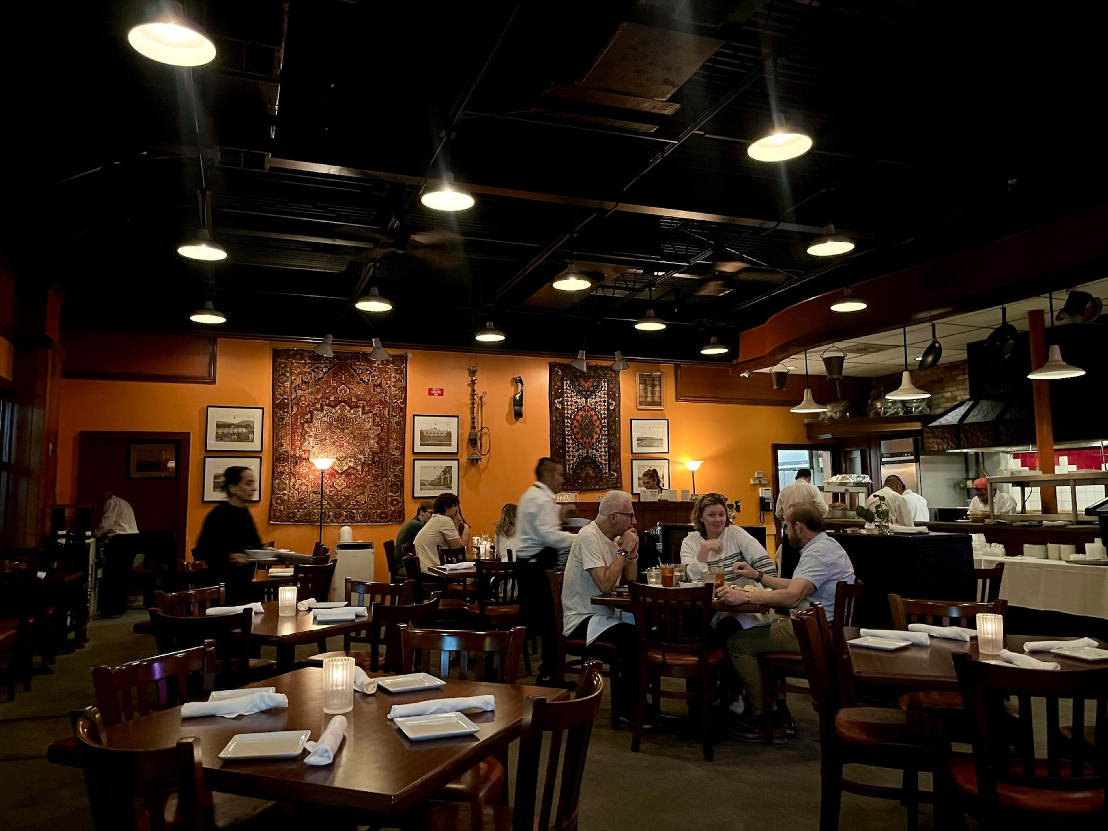 Khyber North Indian Grill interior with orange walls and dark wood tables and chairs