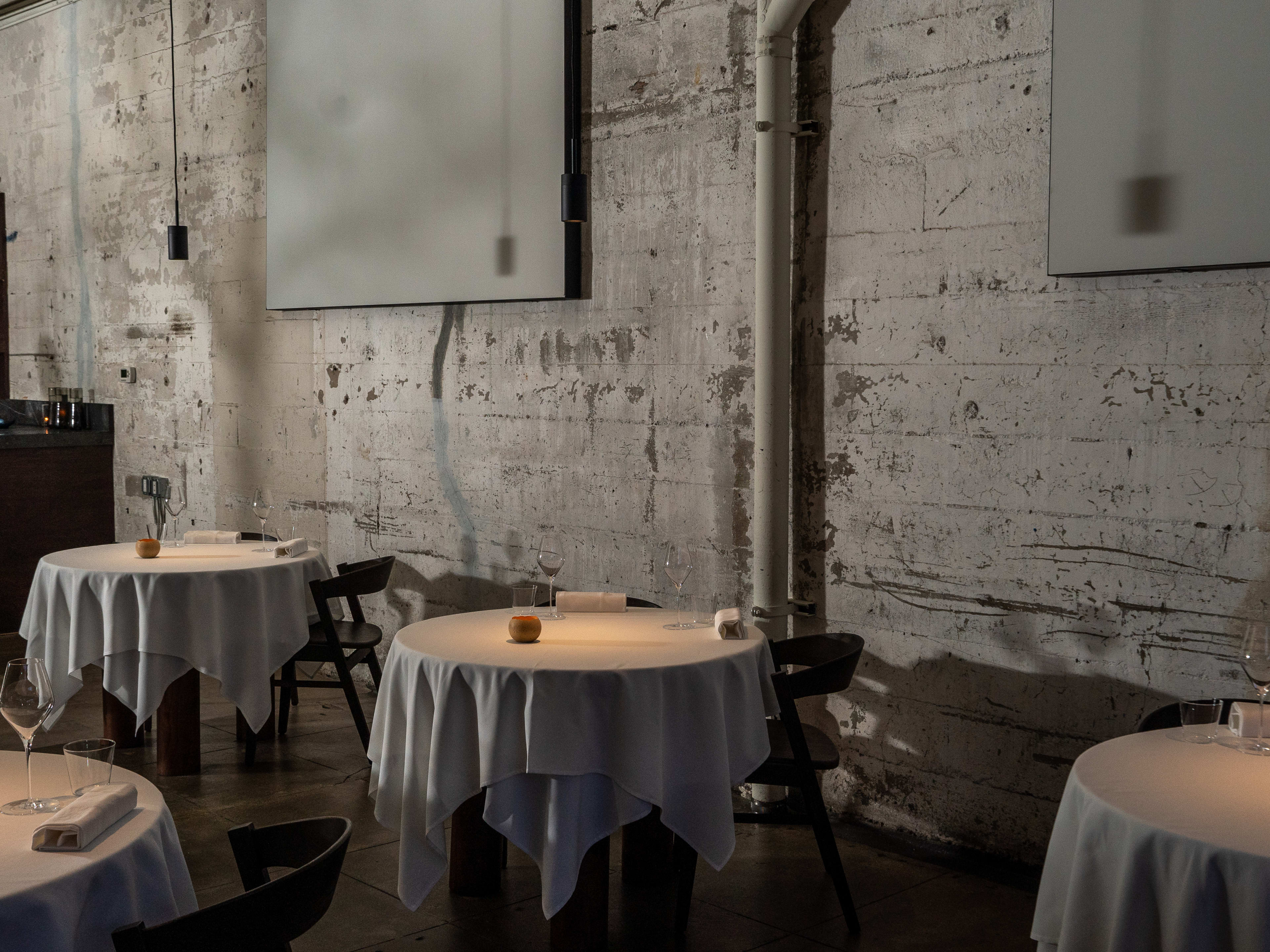 Four tables layered with white tablecloths.