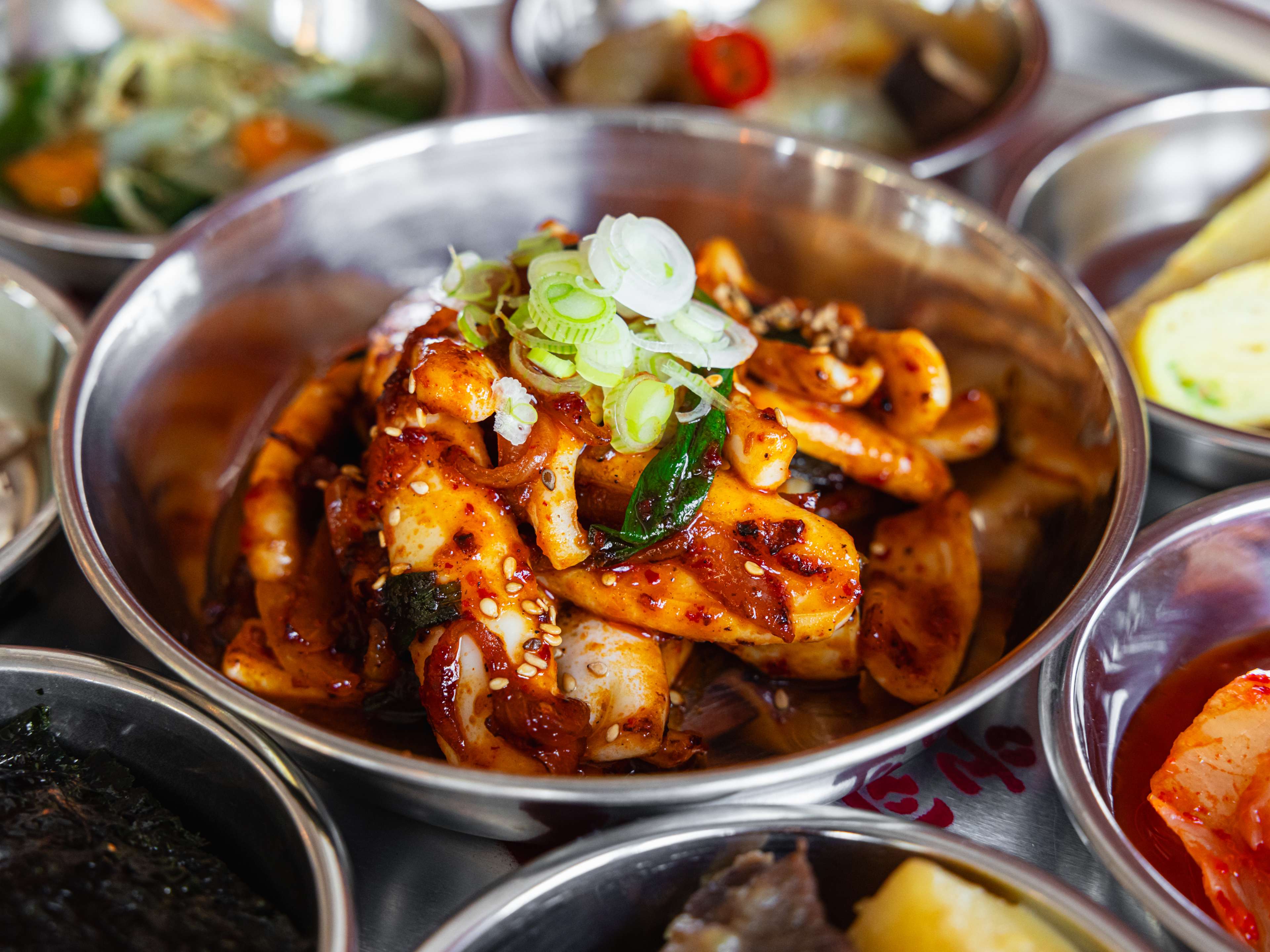 A small bowl of squid coated with gochujang.