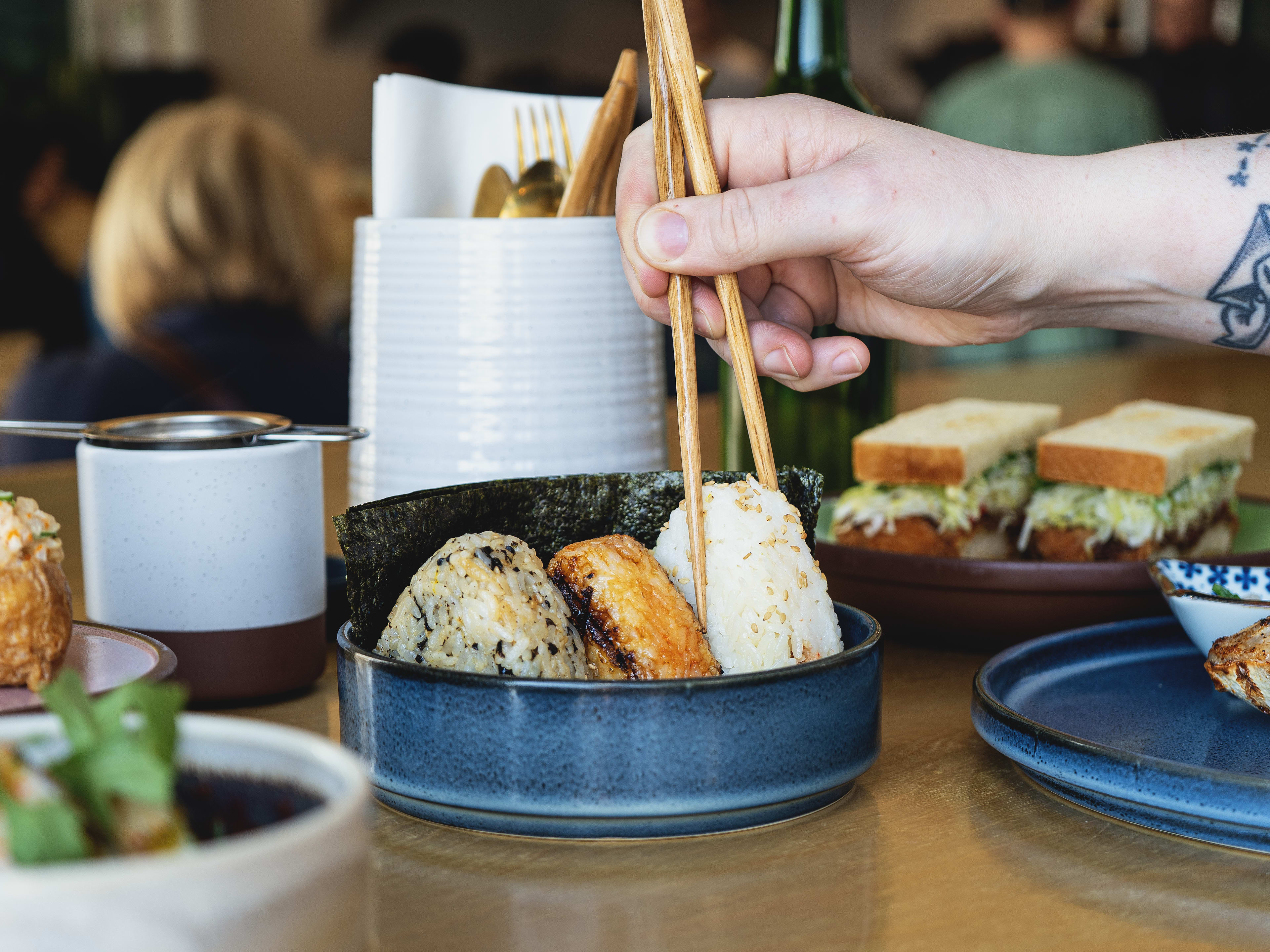 Three-piece onigiri along with spread of Japanese food at Kisser