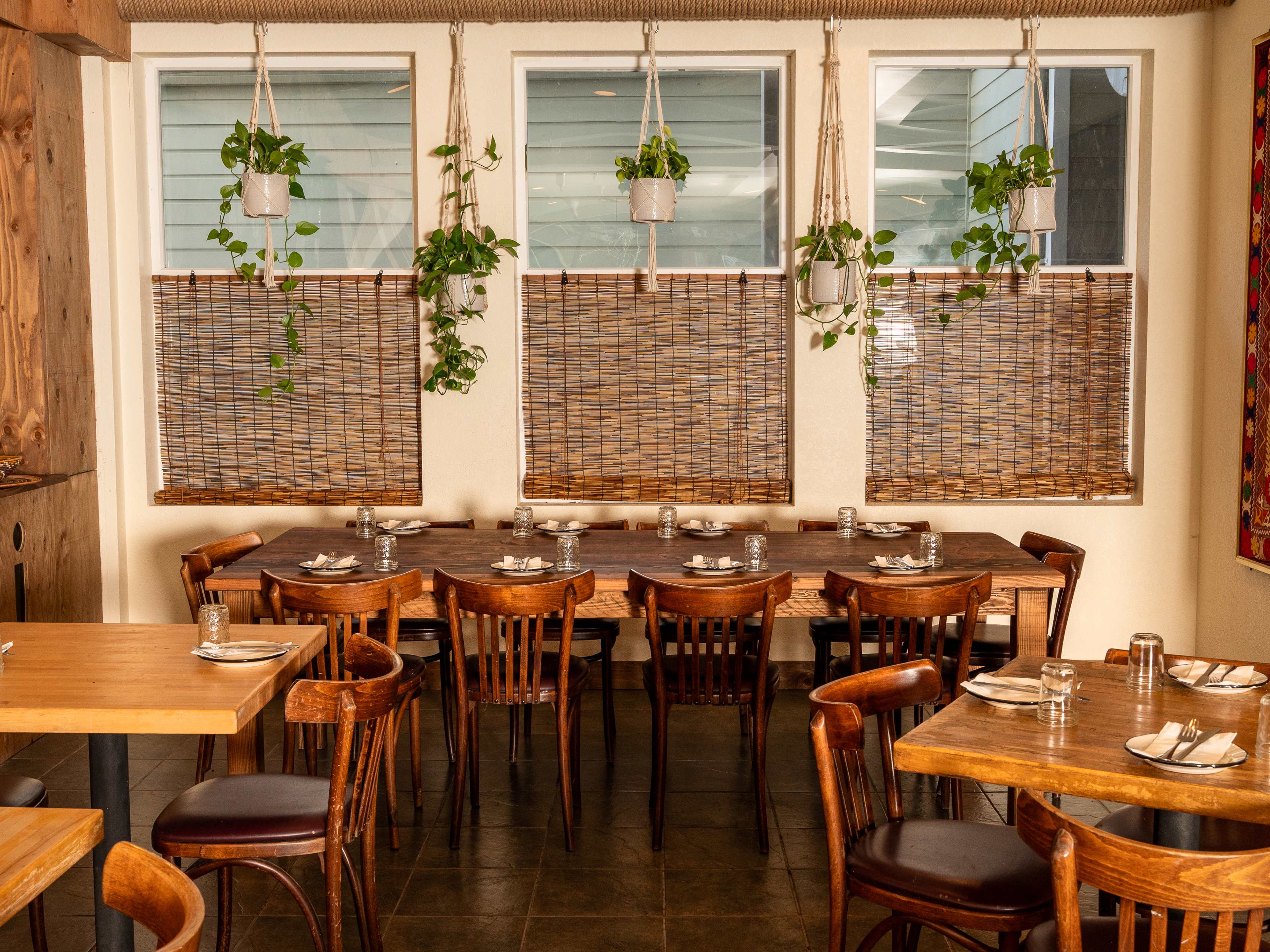 A table and rugs on the wall at Komaaj Mazze Wine Bar