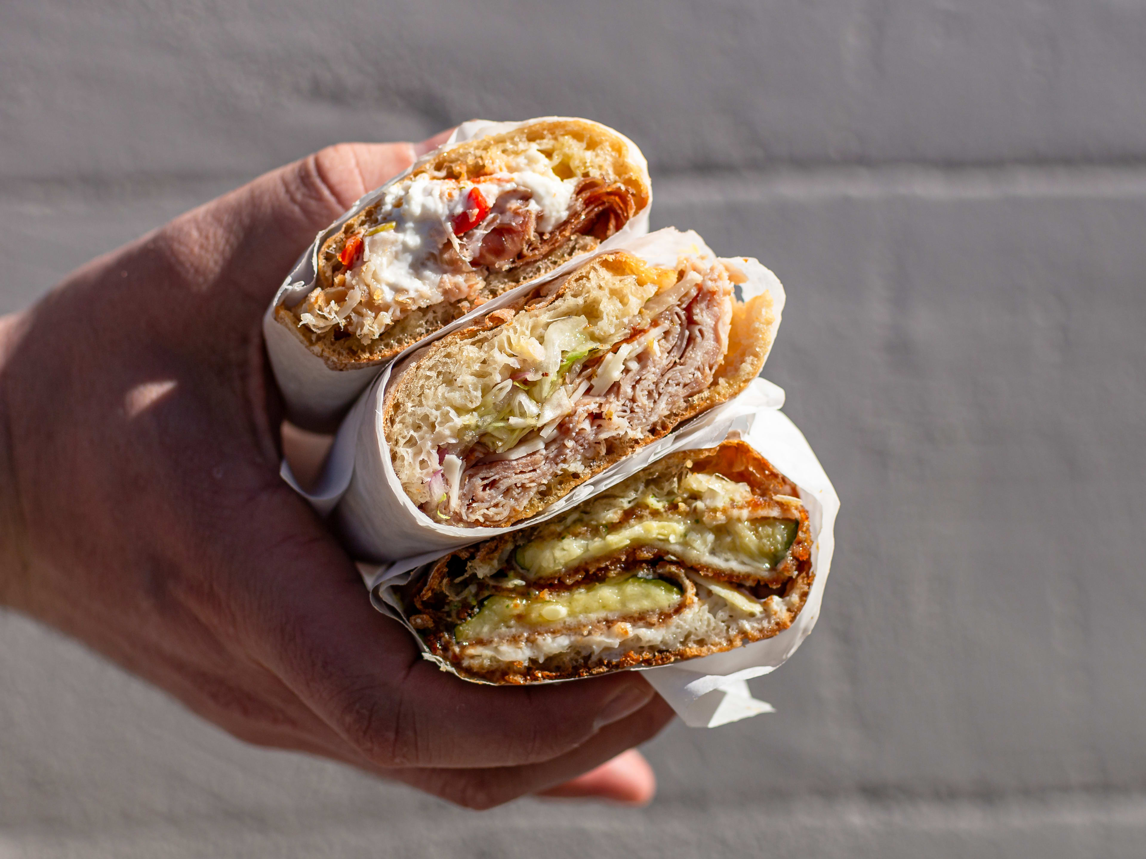 A stack of three sandwiches from The Cheese Store Of Beverly Hills.