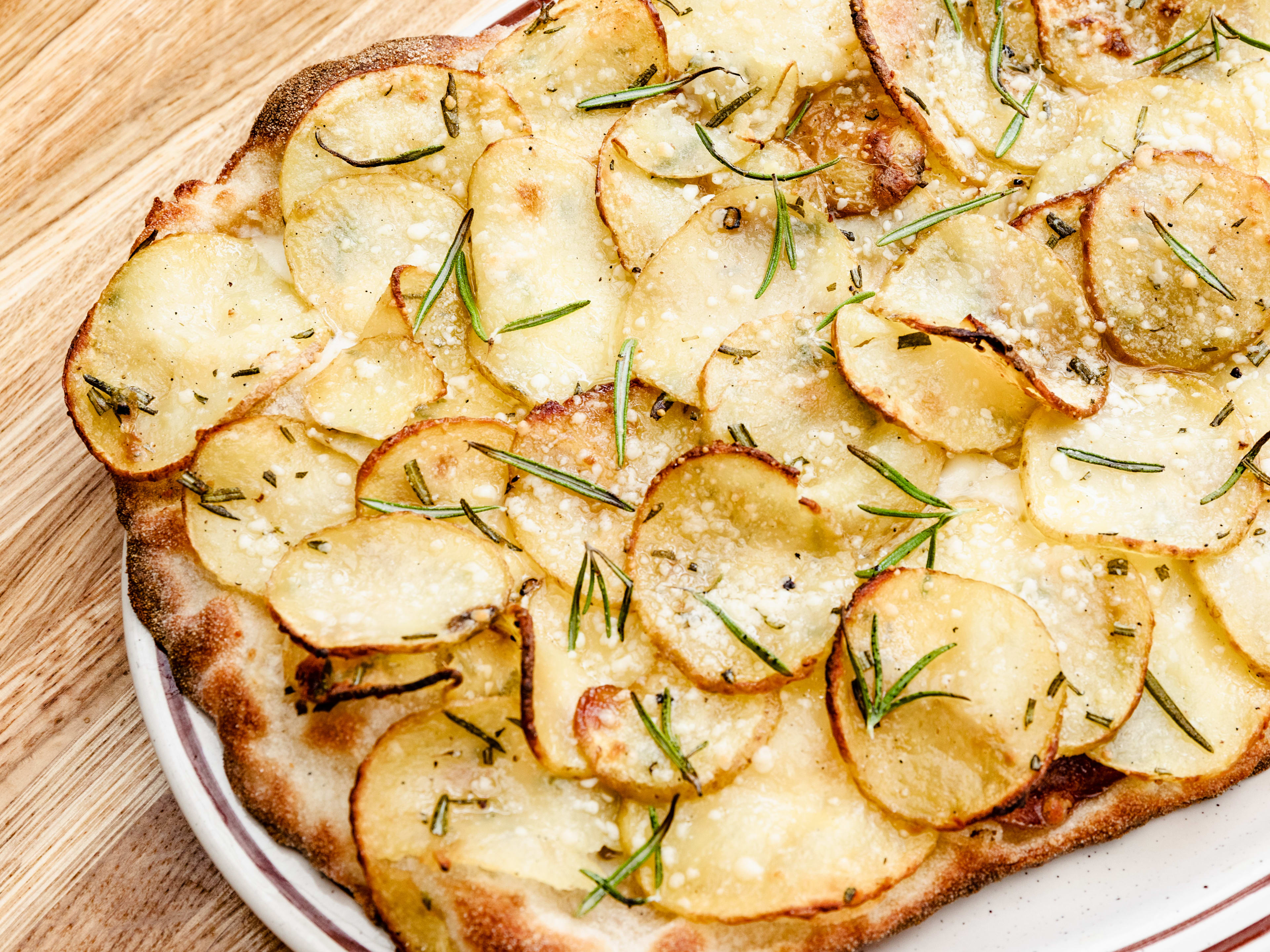 The Patate Pinsa from Oste served on a white plate.