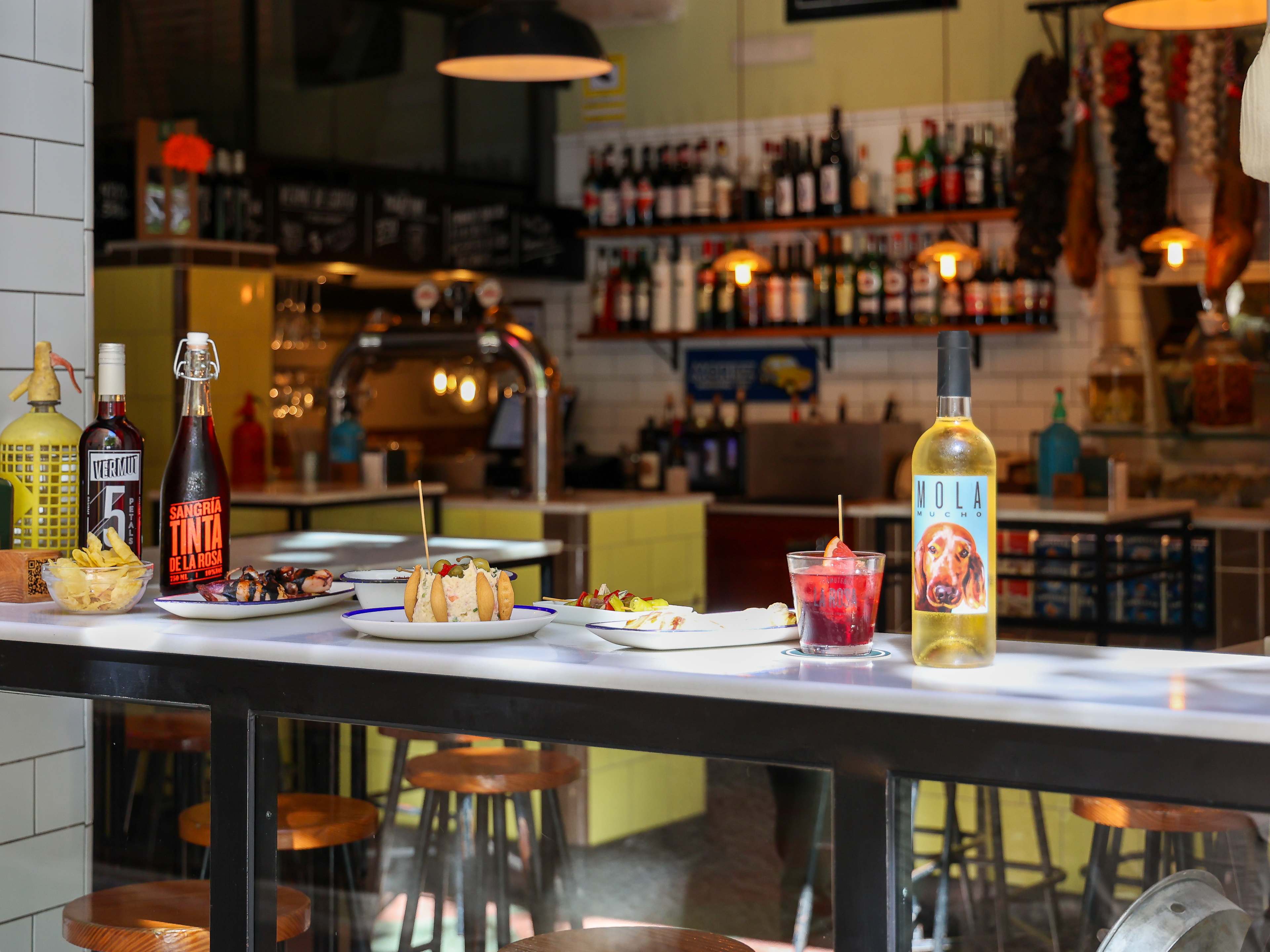 tapas and vermouth drinks on rail at wine bar