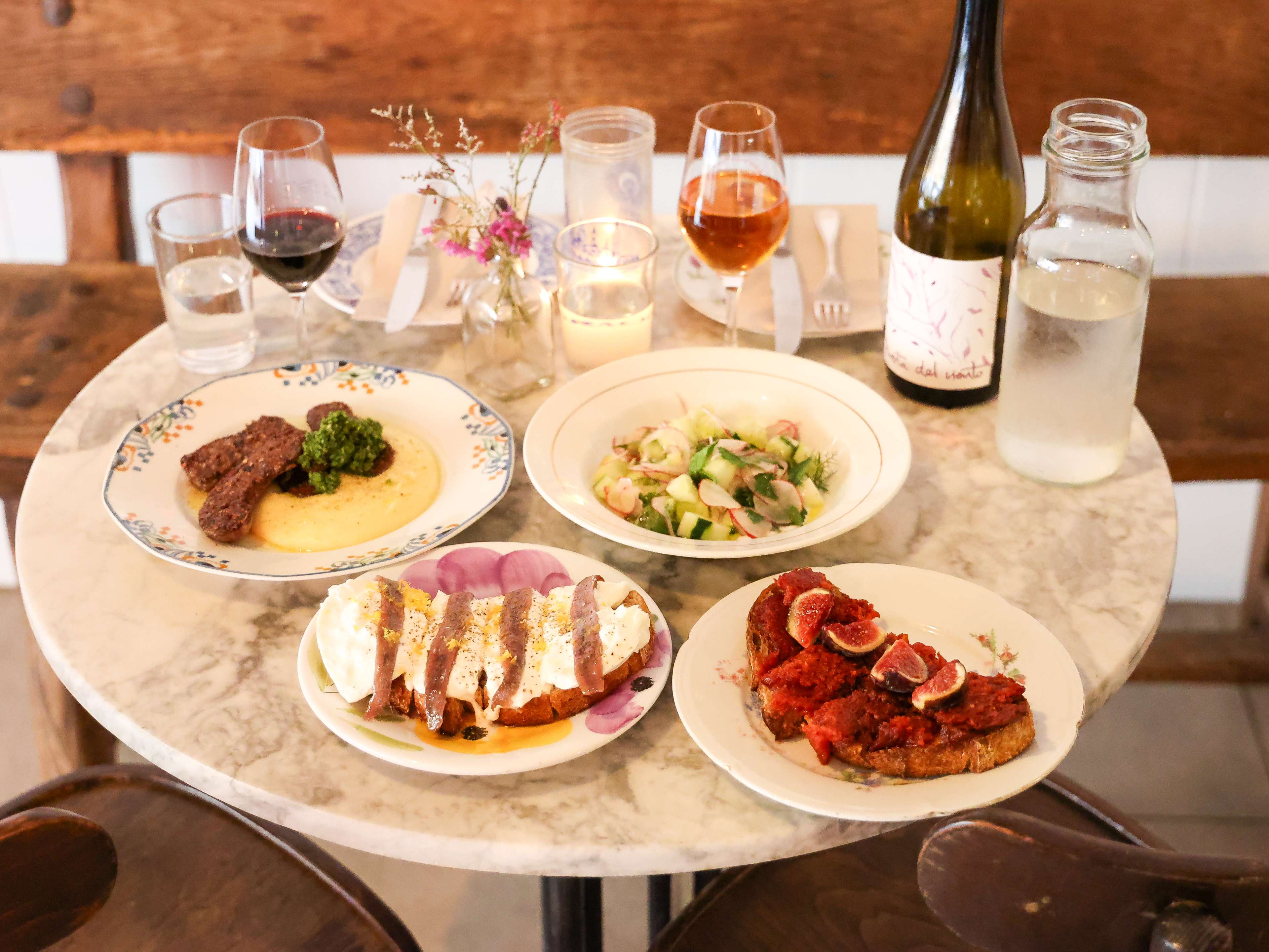 spread of tapas dishes and wine on small marble table